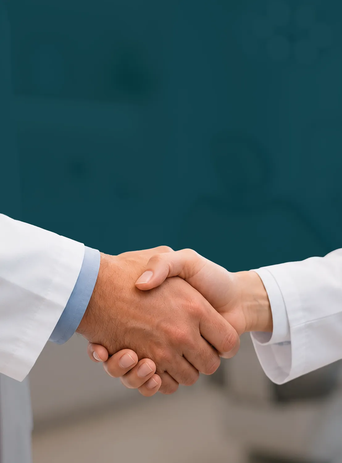 Two people wearing white coats shaking hands, symbolizing agreement or partnership.