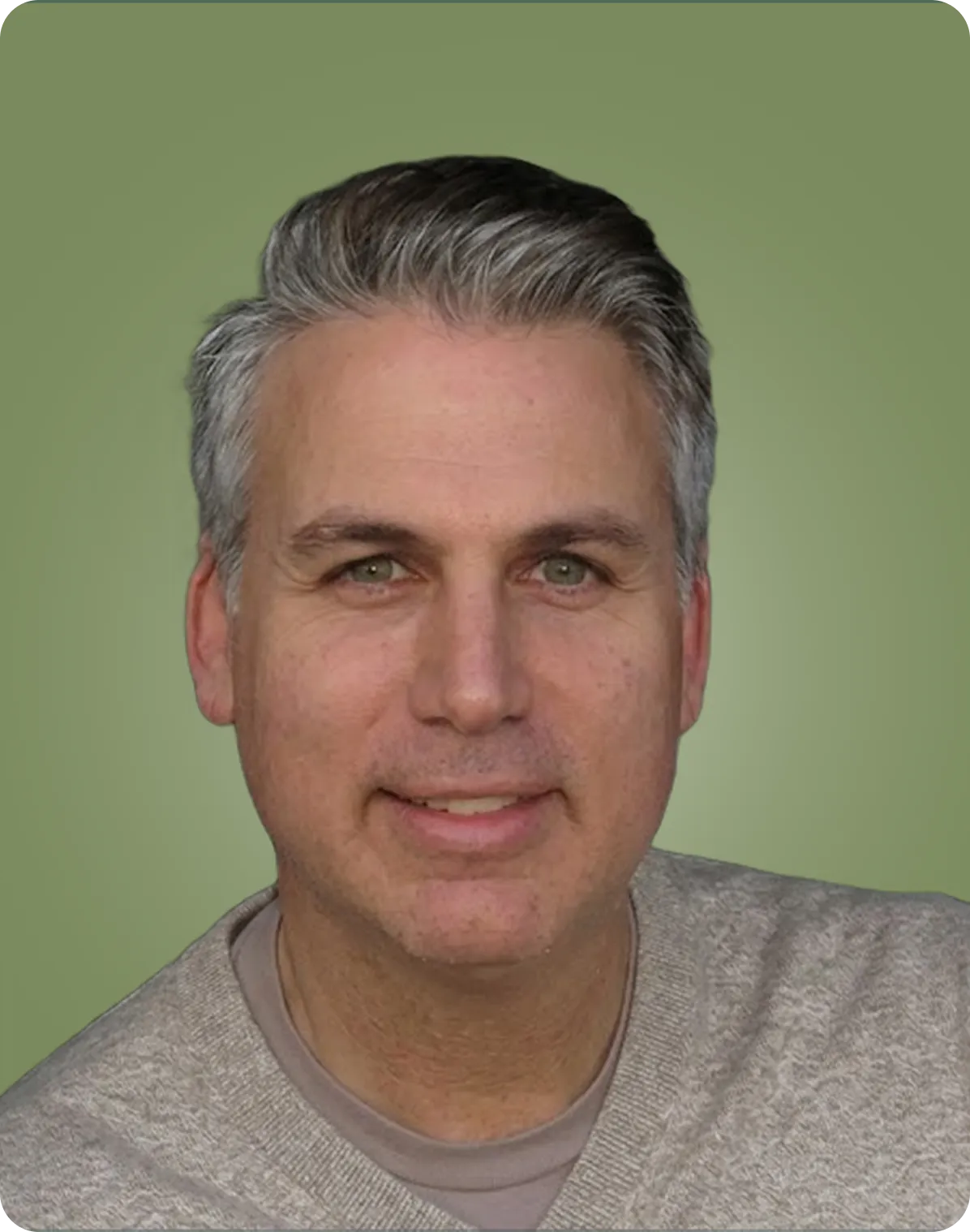 Smiling middle-aged man with short gray hair, green eyes, wearing a gray sweater and a light gray shirt, against a muted green background.