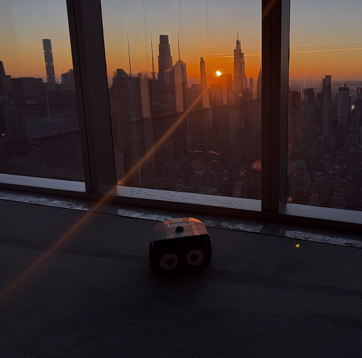 Robotic construction printer overlooking the New York City skyline at sunset