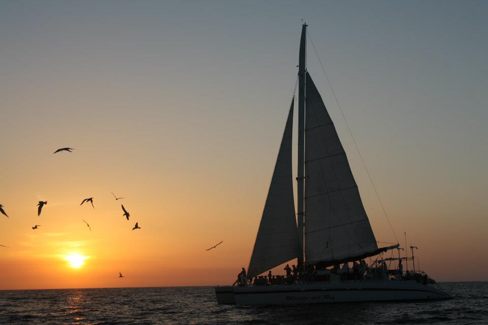 Marlin del Rey catamaran silhouetted against the sunset