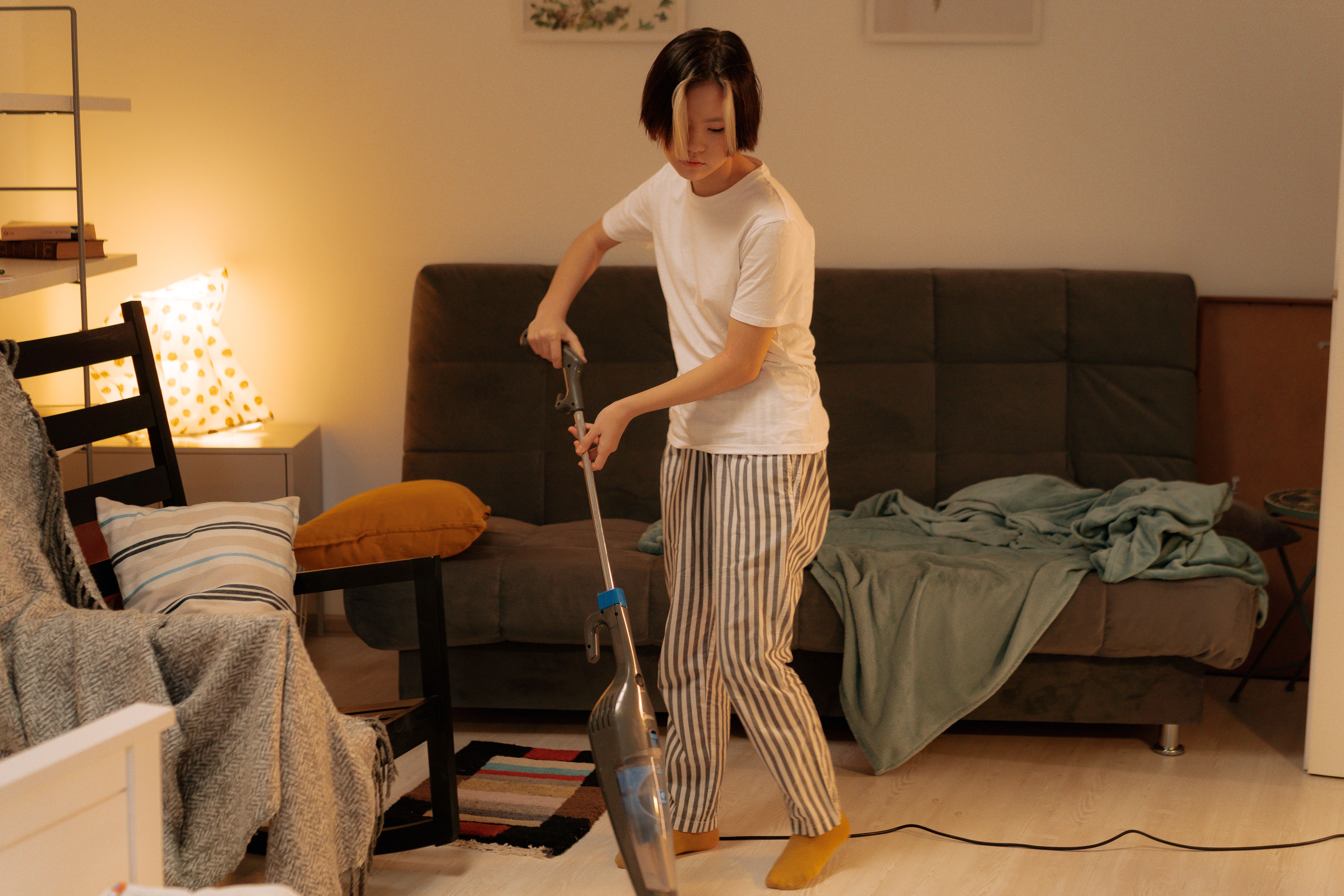A cleaner vacuuming a living room floor during a Marina Gleam standard cleaning session