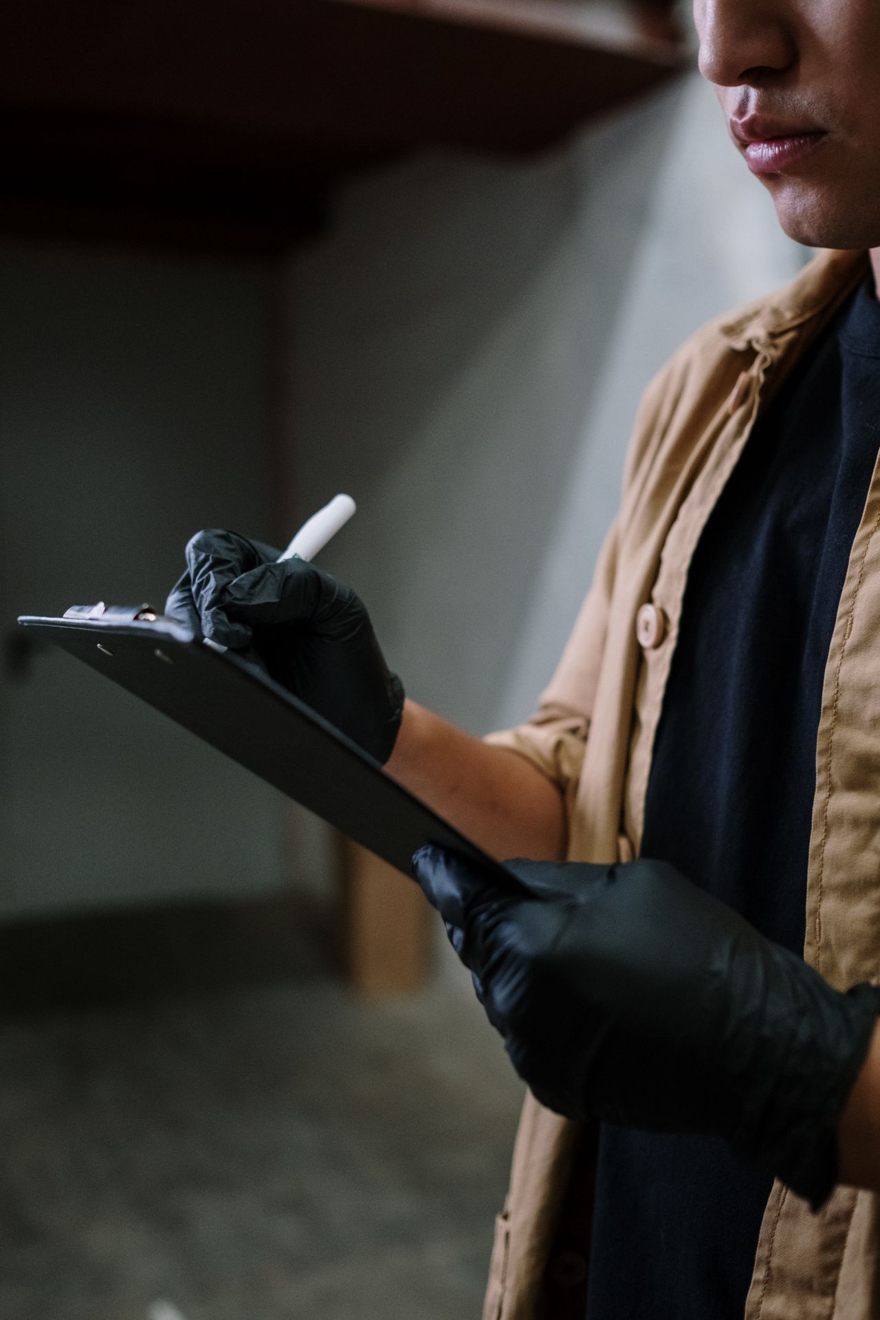 A gloved professional reviewing a checklist, representing what to verify before booking a cleaning company