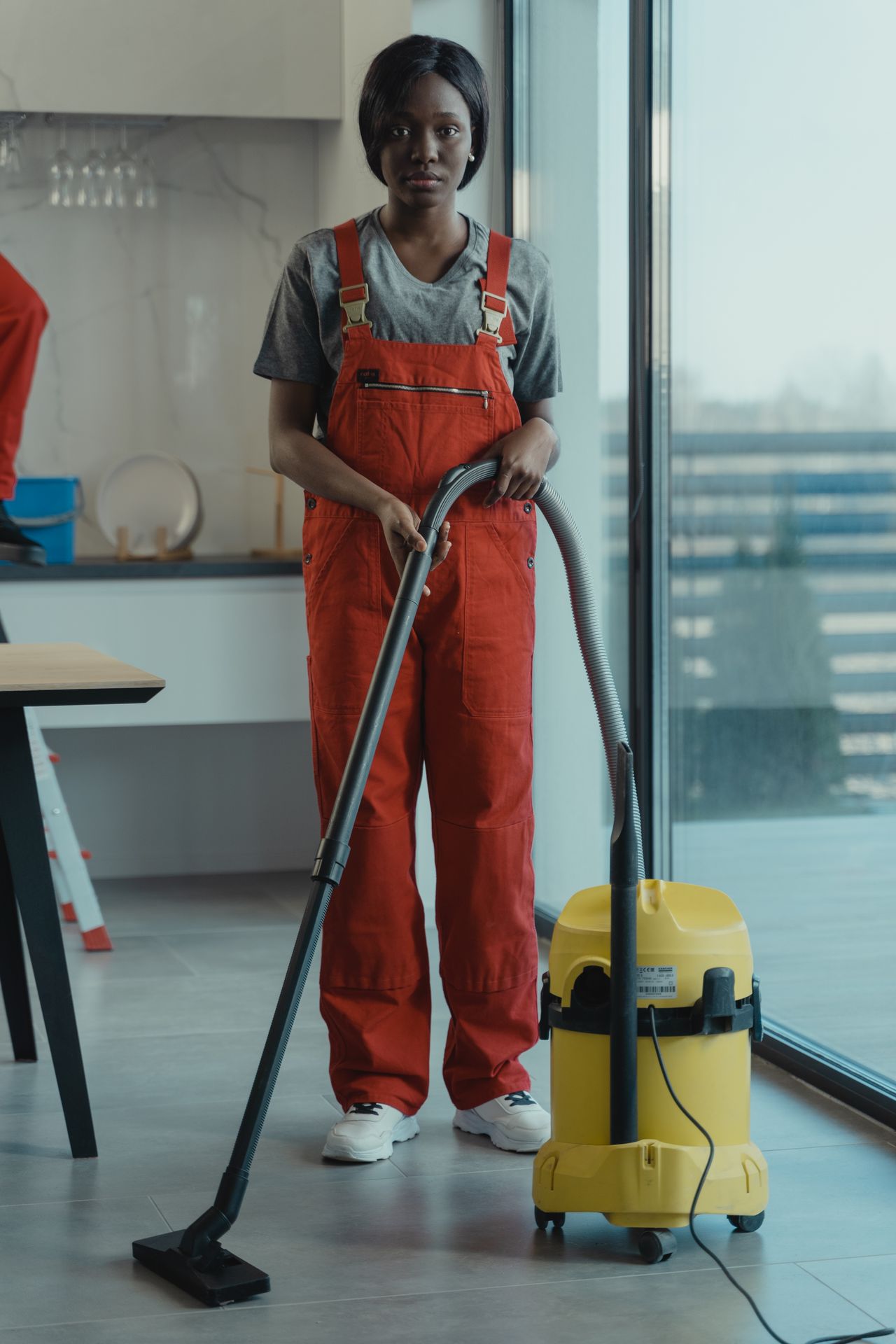A professional cleaner in coveralls operating equipment on a carpet, representing carpet steam cleaning as a booked add-on