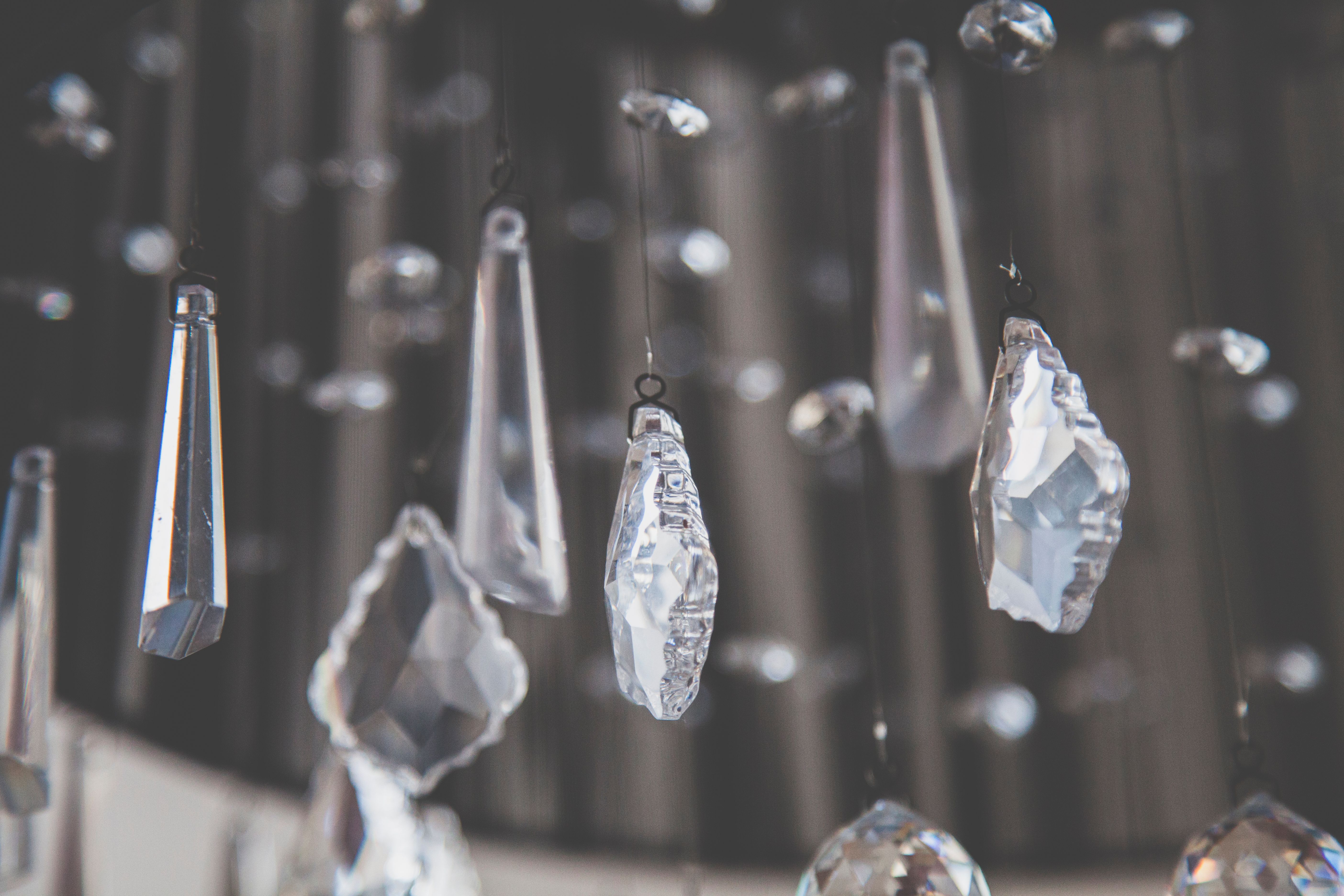 Close-up view of elegant hanging crystals from a chandelier, highlighting sparkling details.