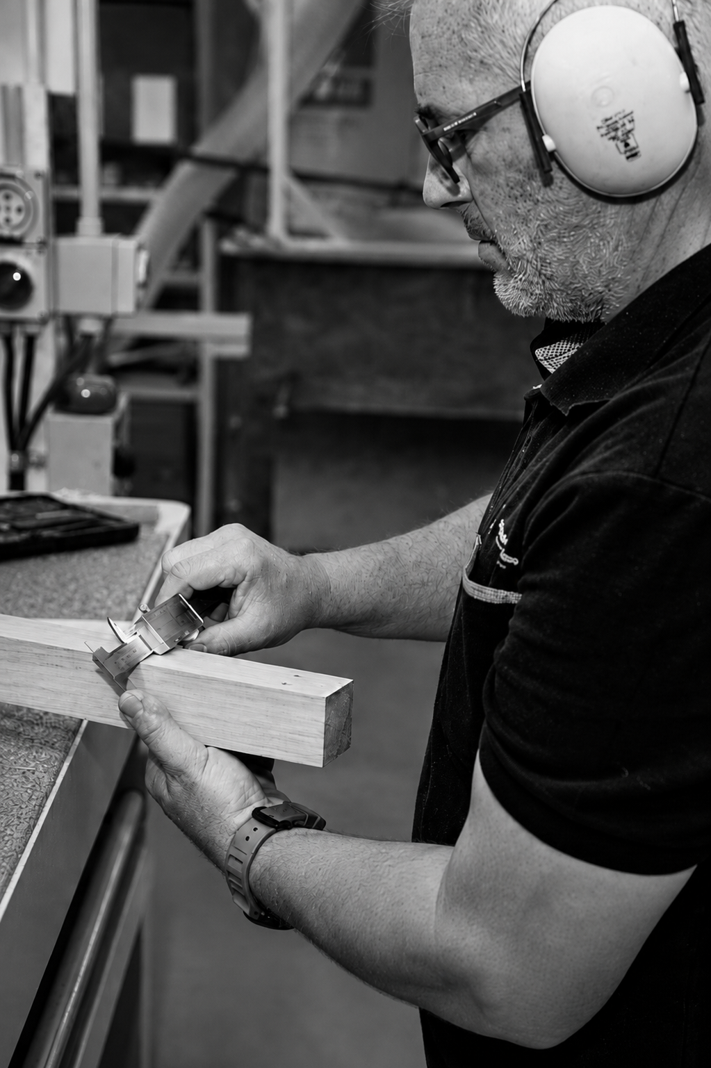 Evolution team member checking a timber component with calipers in the Auckland workshop