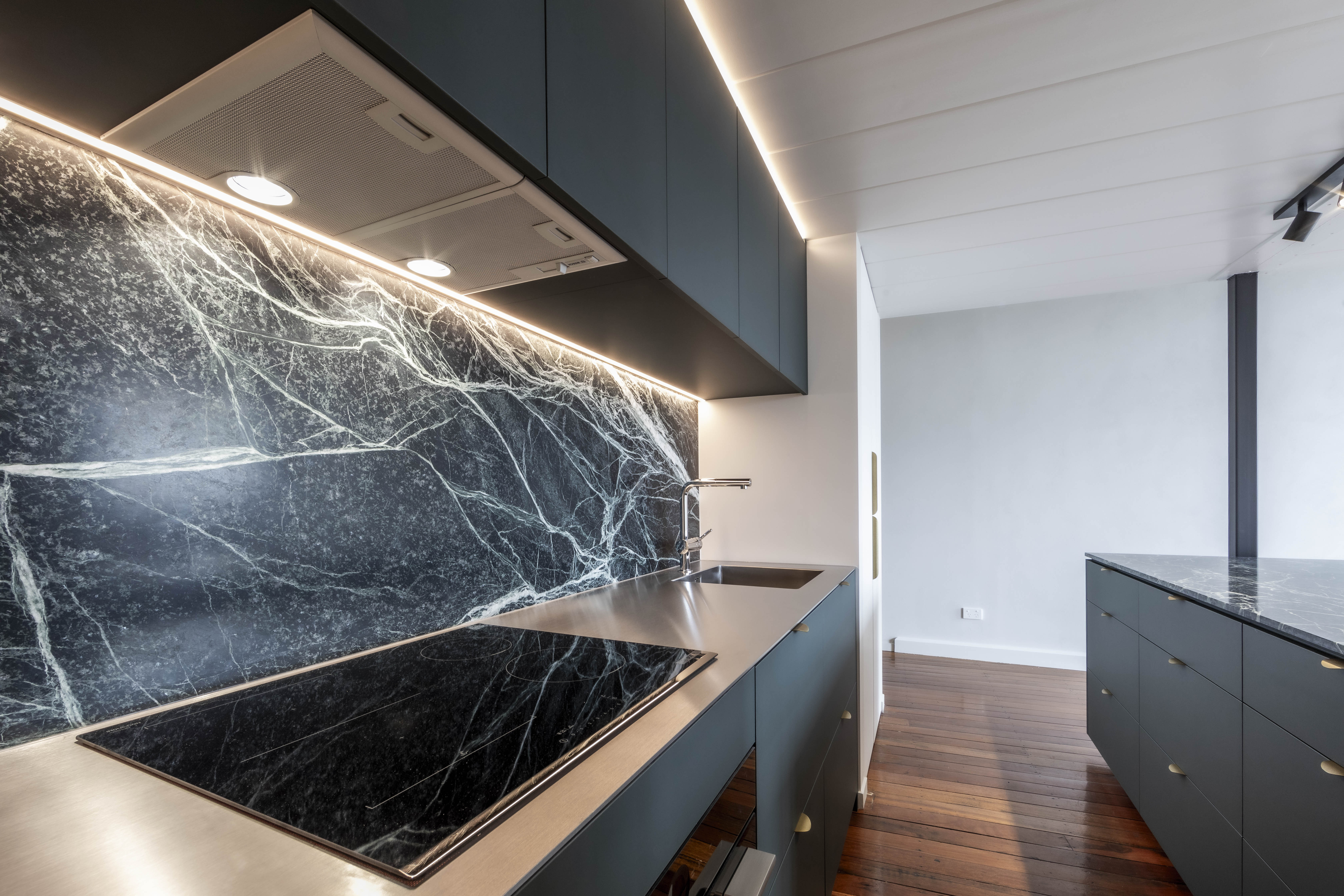 Cooktop, stone splashback and custom cabinetry detail at George Court Apartment