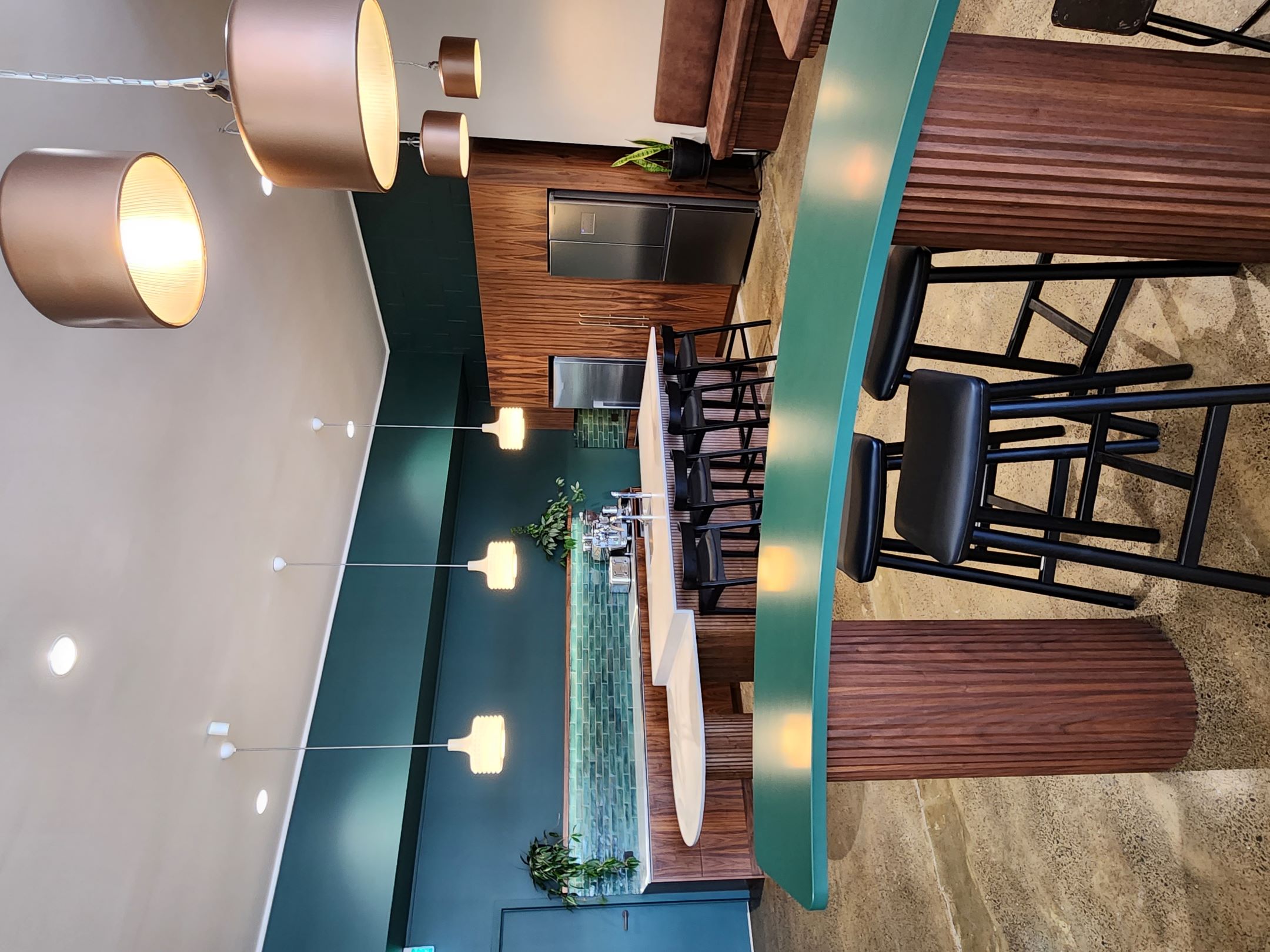 Finch Office staff kitchen with curved green-edged table, ribbed timber bases and integrated cabinetry