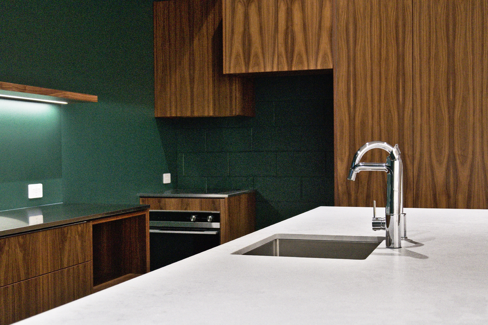 Finch Office kitchen with timber-grain cabinetry, white stone worktop and integrated sink