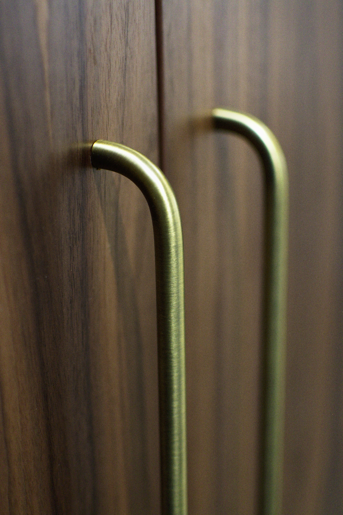 Brass-toned curved handles on timber-grain cabinetry at Finch Office