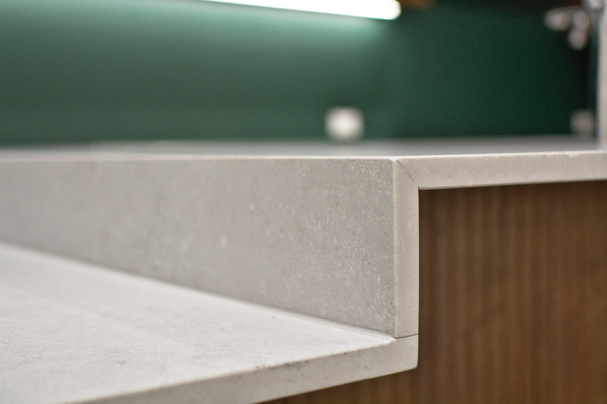 Mitred stone worktop junction above timber-grain cabinetry at Finch Office