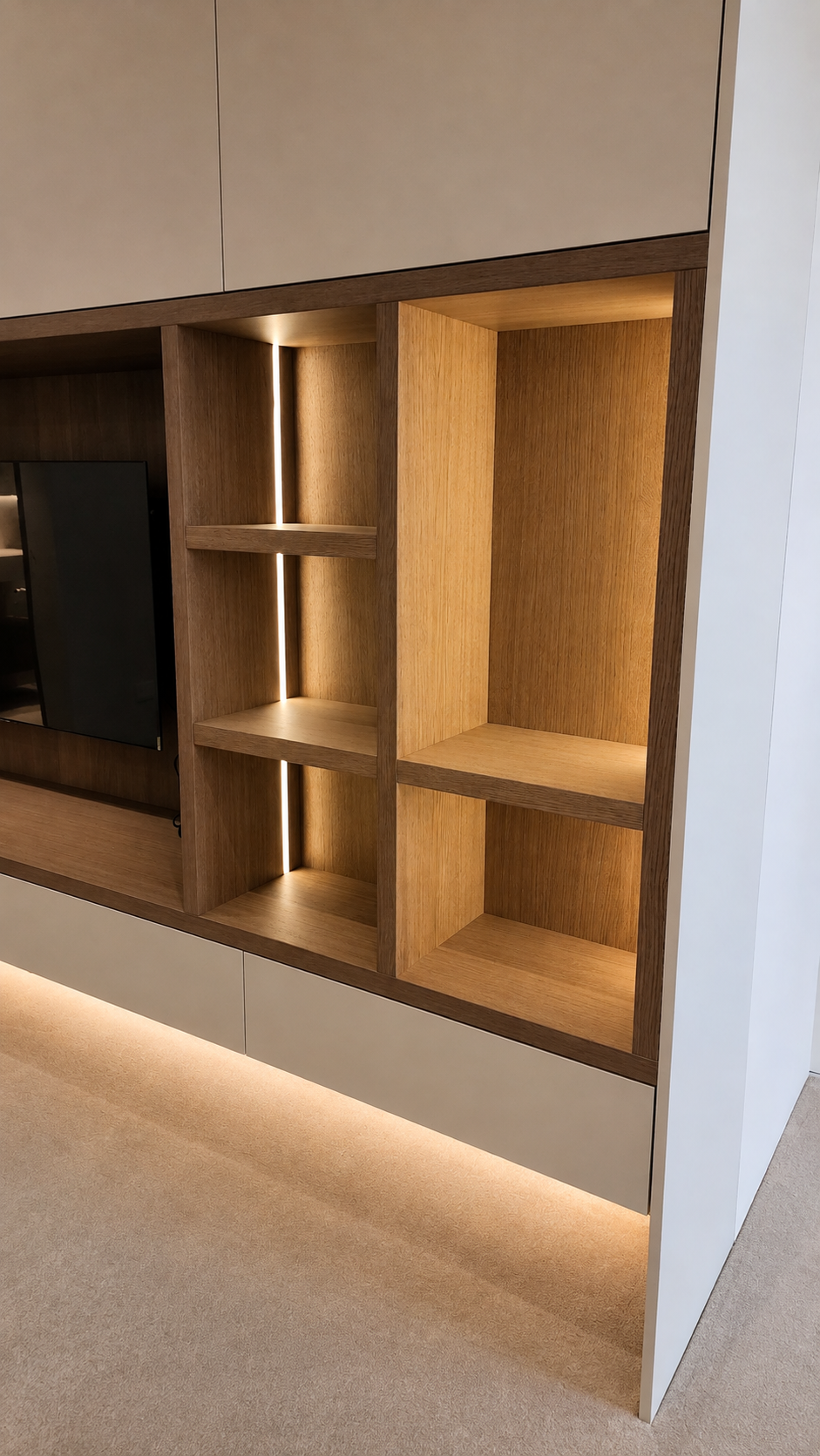 Bedroom wardrobe and integrated TV cabinetry with illuminated oak shelving at Mauao Residence