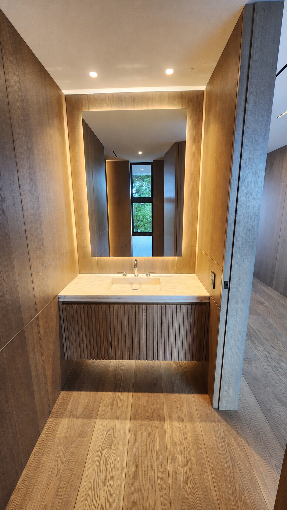 Illuminated timber-lined vanity at Mauao Residence