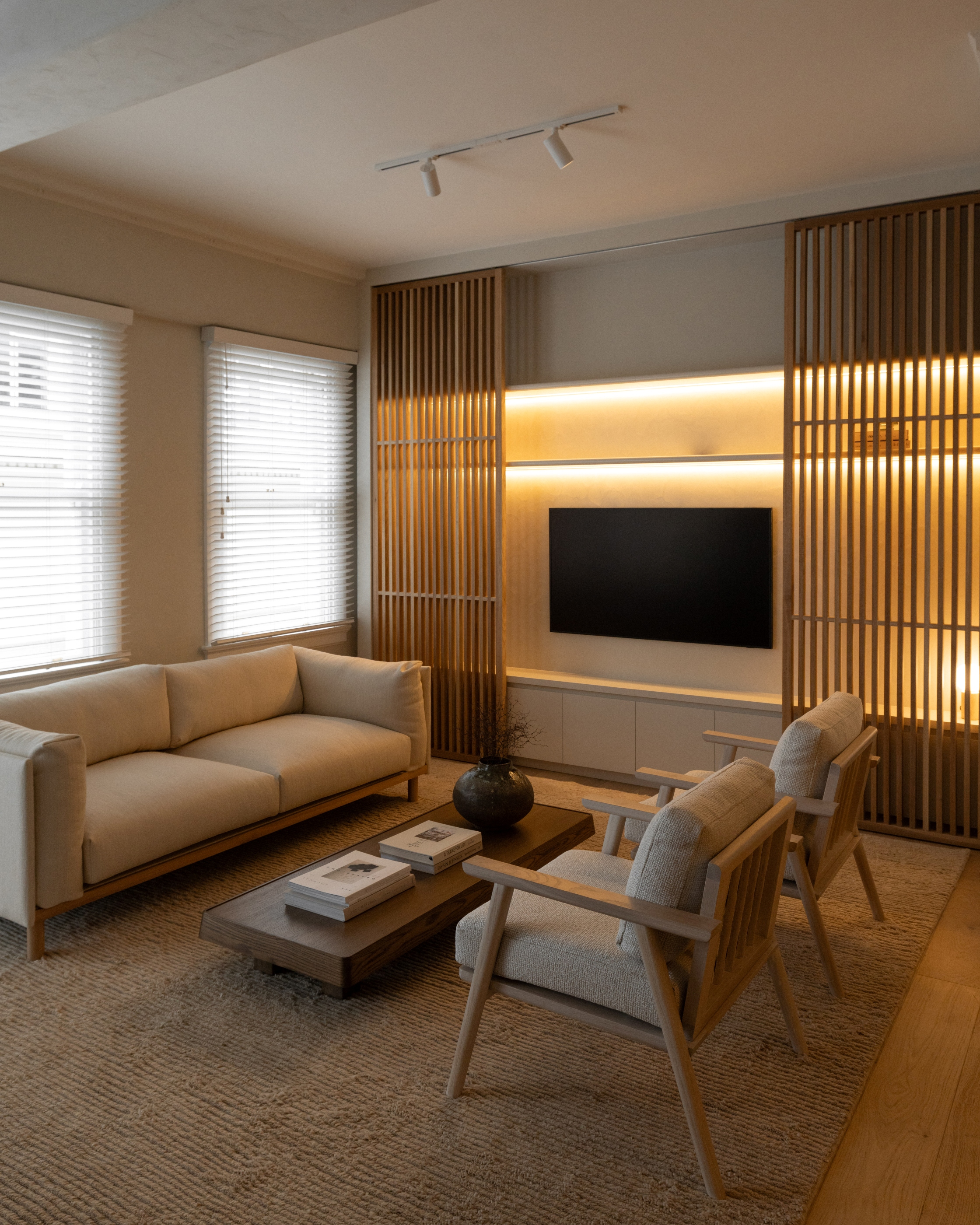 Living room at Westminster Court with illuminated timber sliding screen and integrated media cabinetry