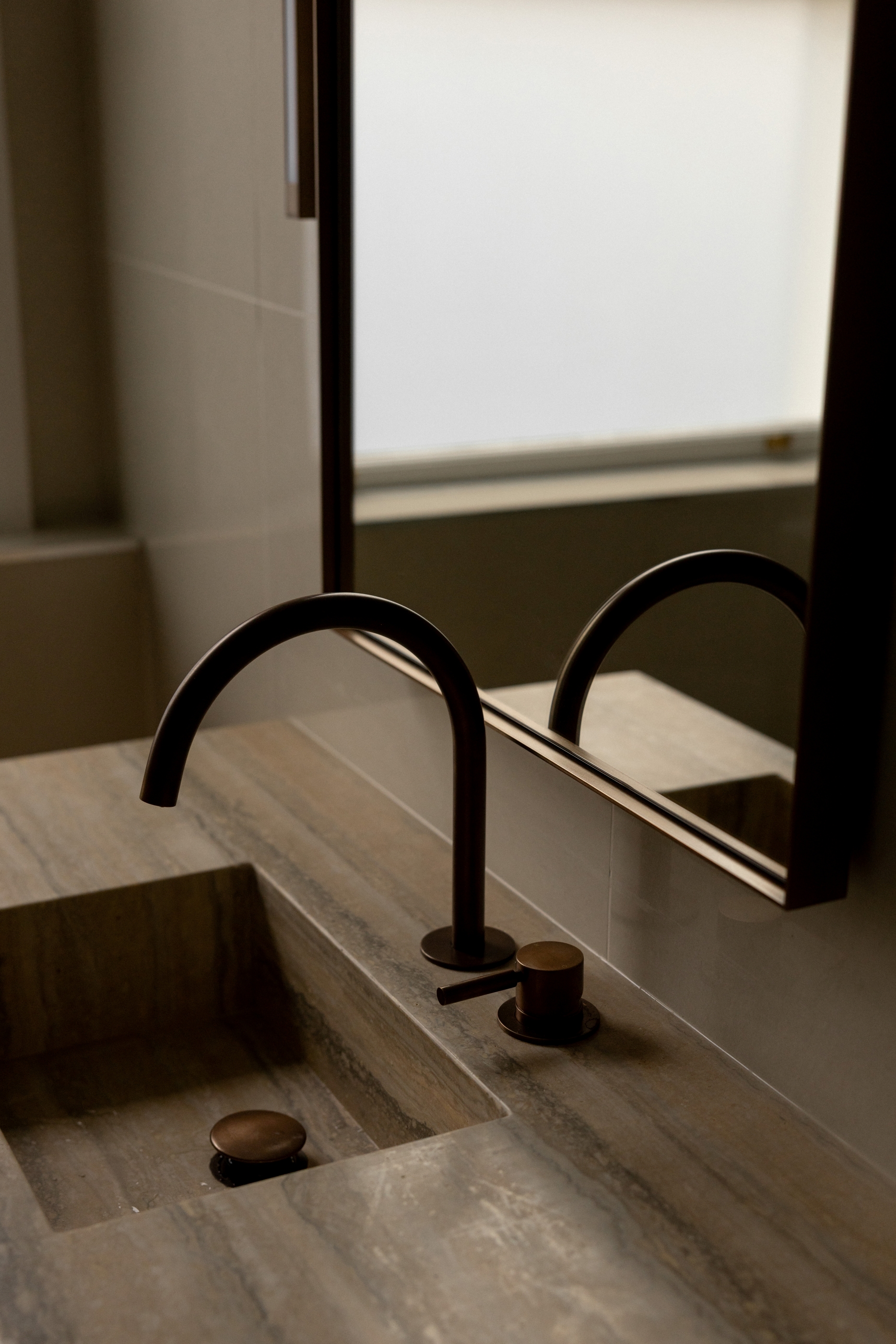 Stone basin and dark satin bronze tapware detail at Westminster Court