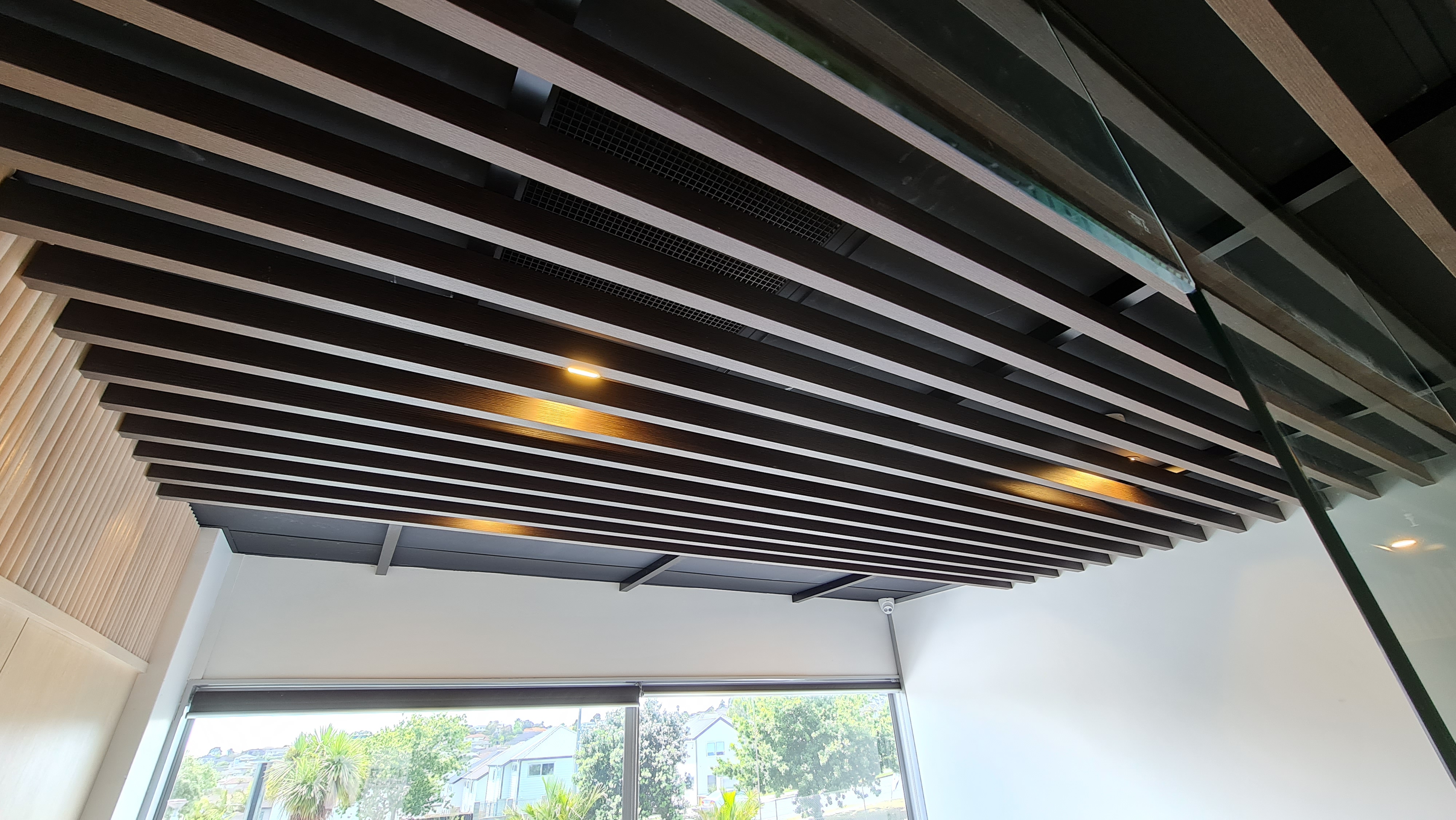 Dark slatted feature ceiling and timber wall detailing at A+ Cosmetic Clinic