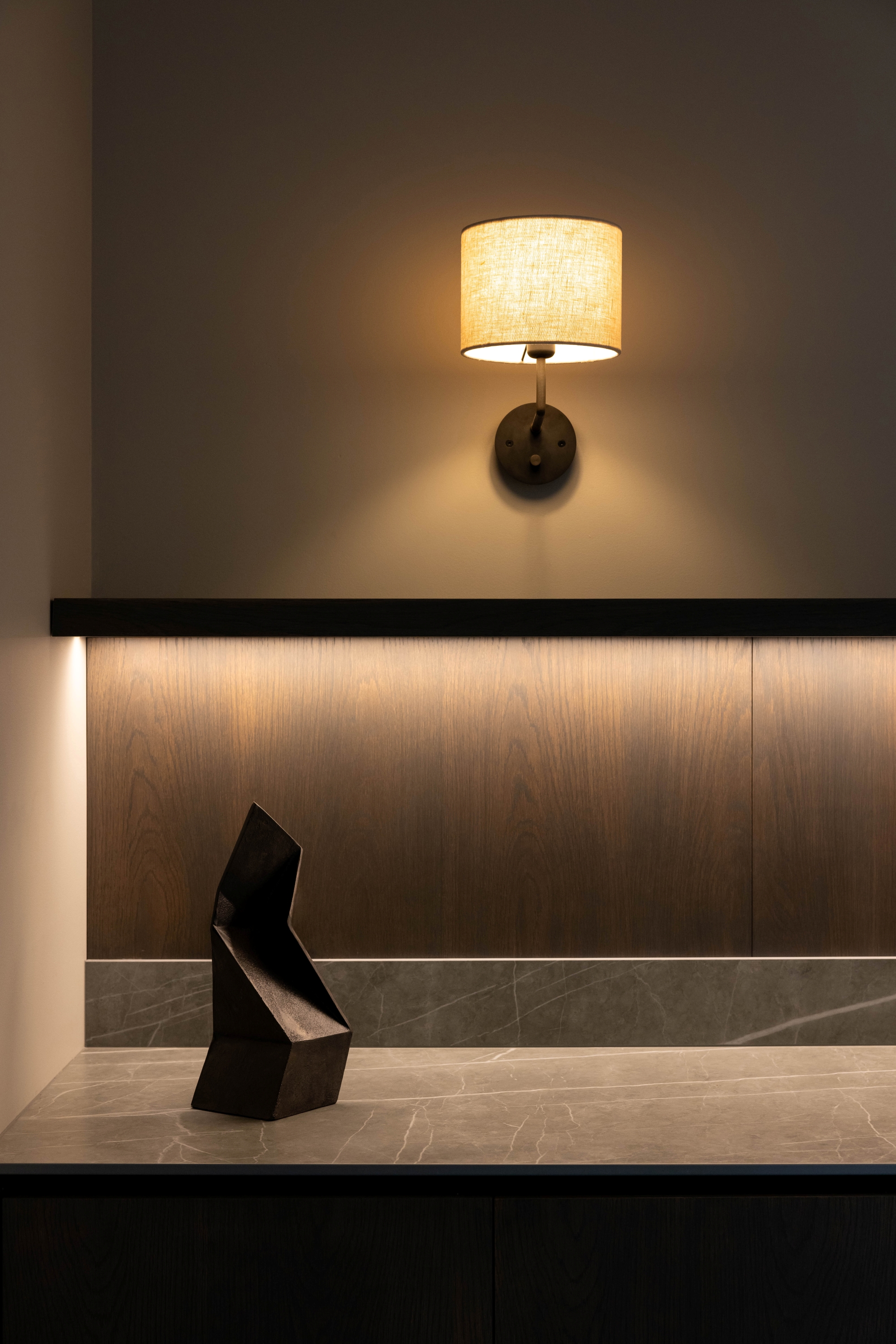 Illuminated timber cabinetry and stone surface detail at Russell McVeagh Offices