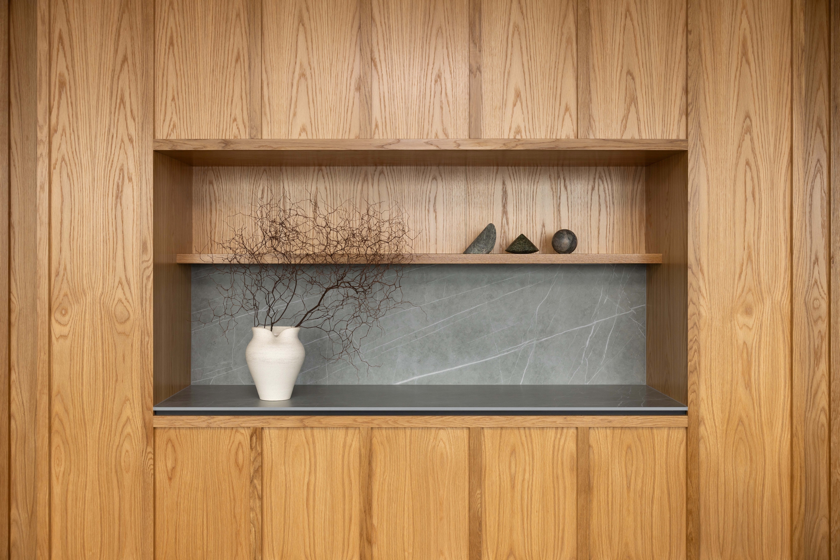 Light oak feature cabinetry with recessed stone-backed display niche at Russell McVeagh Offices