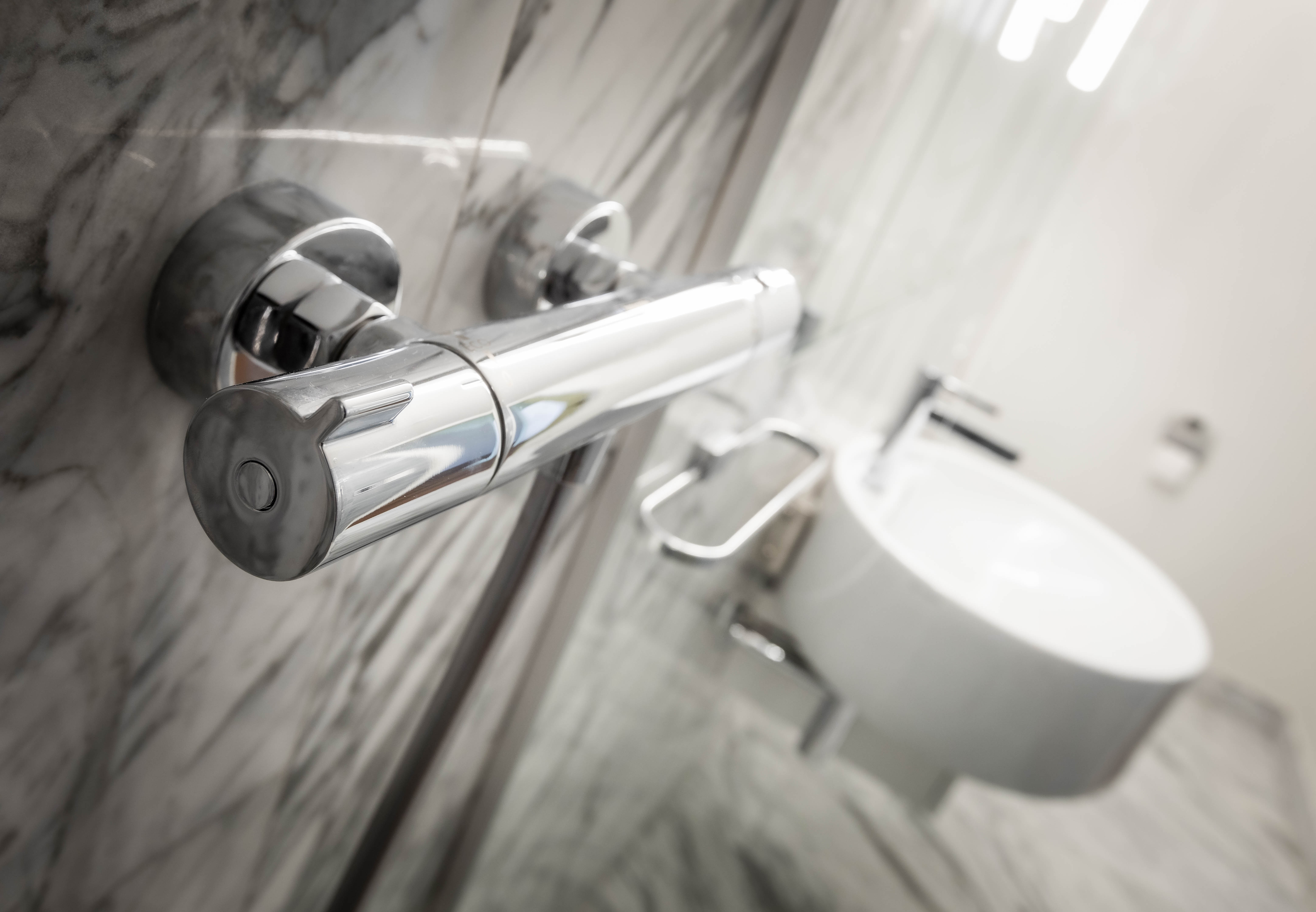 Chrome bathroom fitting against marble wall lining at George Court Apartment