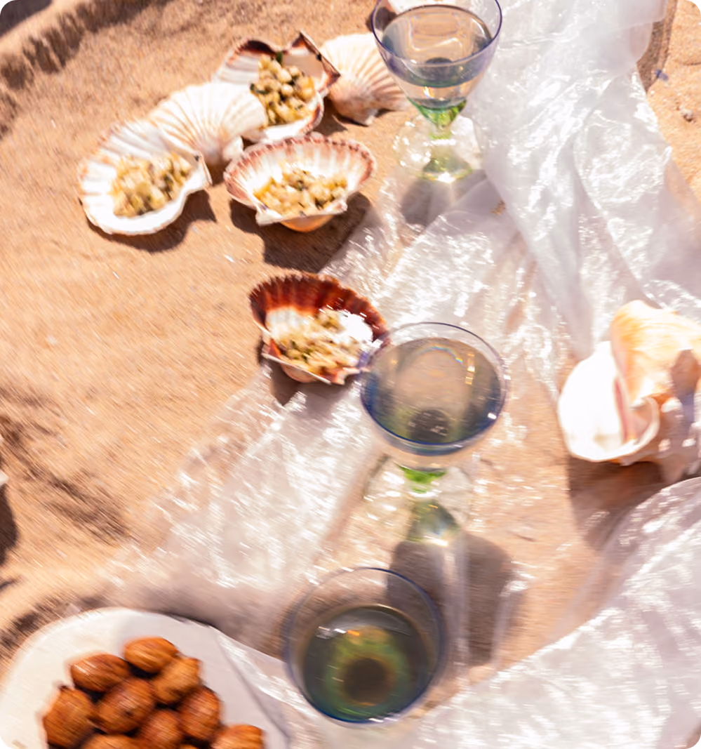 Coquilles Saint-Jacques remplies posées sur une surface avec des verres et des fruits secs.