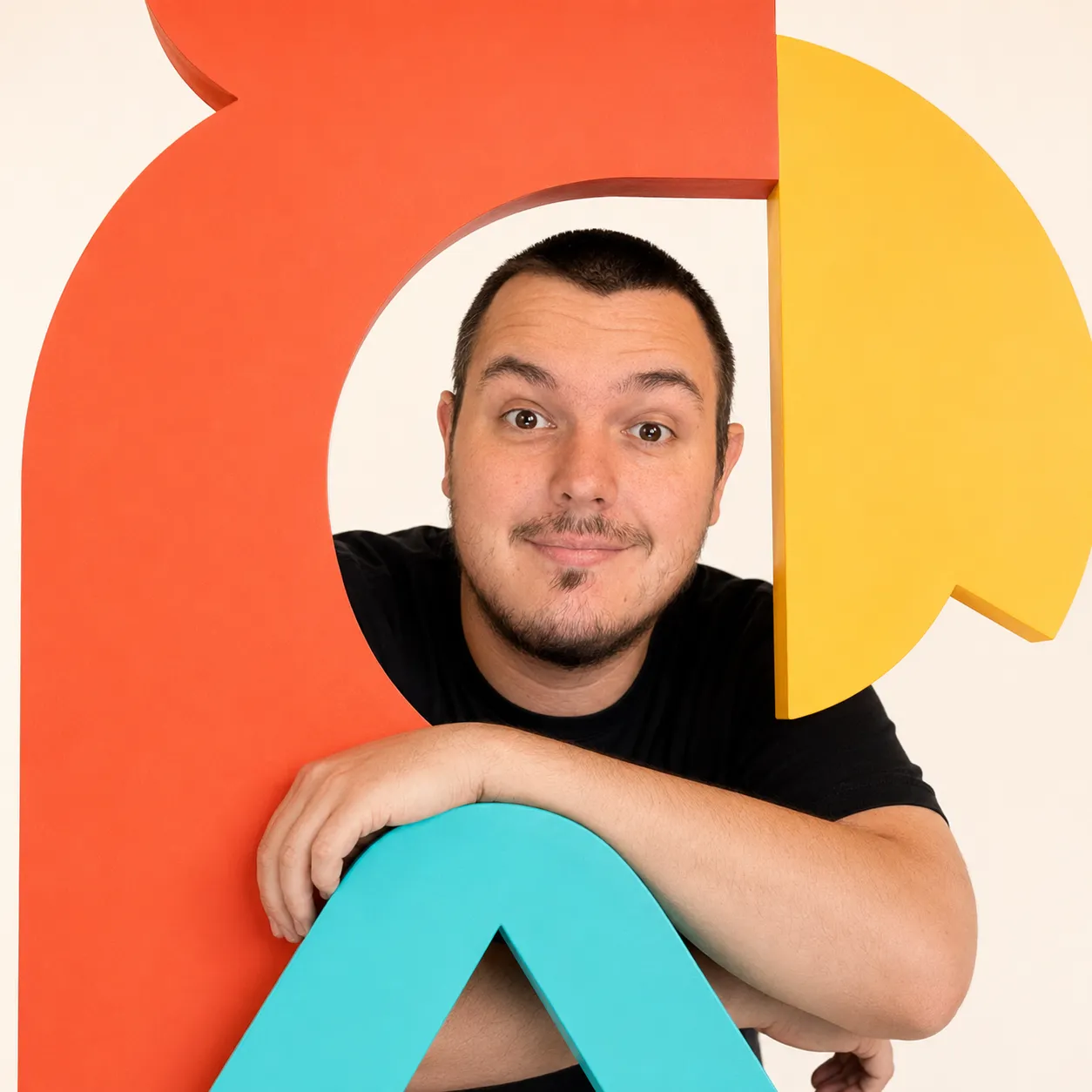 Portrait du designer devant des formes colorées de l’identité visuelle