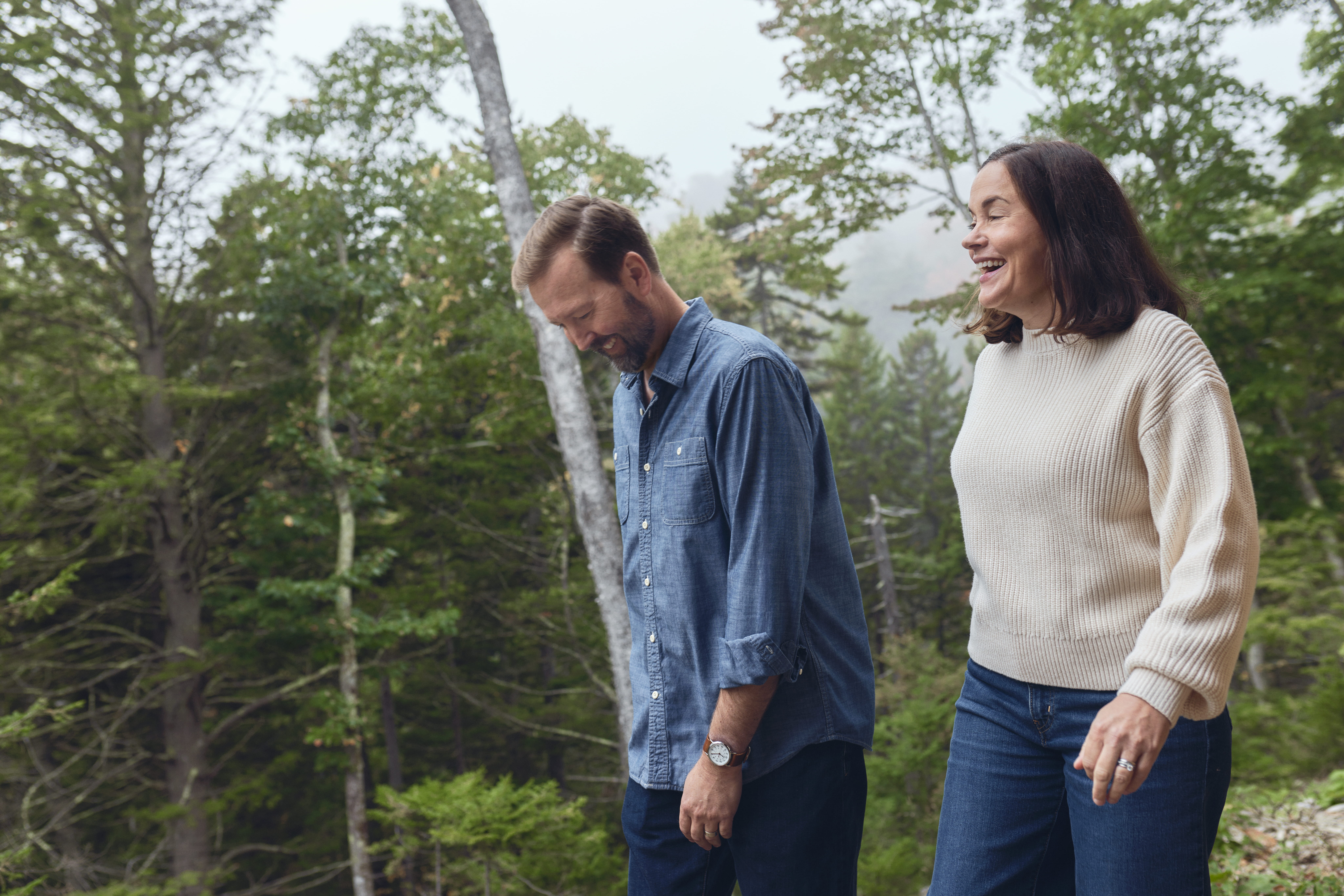 Brie and David Pio sharing a laugh among the birch trees in Camden Hills State Park