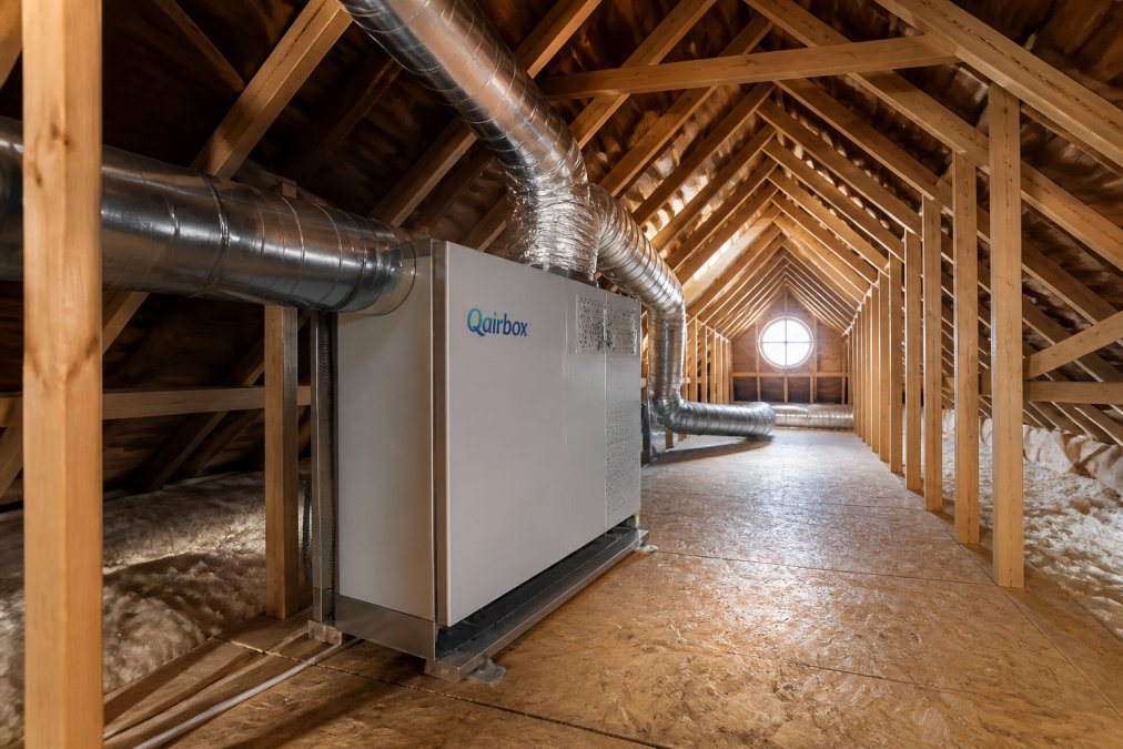 A quiet, modern attic space with a professionally installed standalone whole-home air purification unit mounted out of the way, soft lighting, and clean ductwork visible