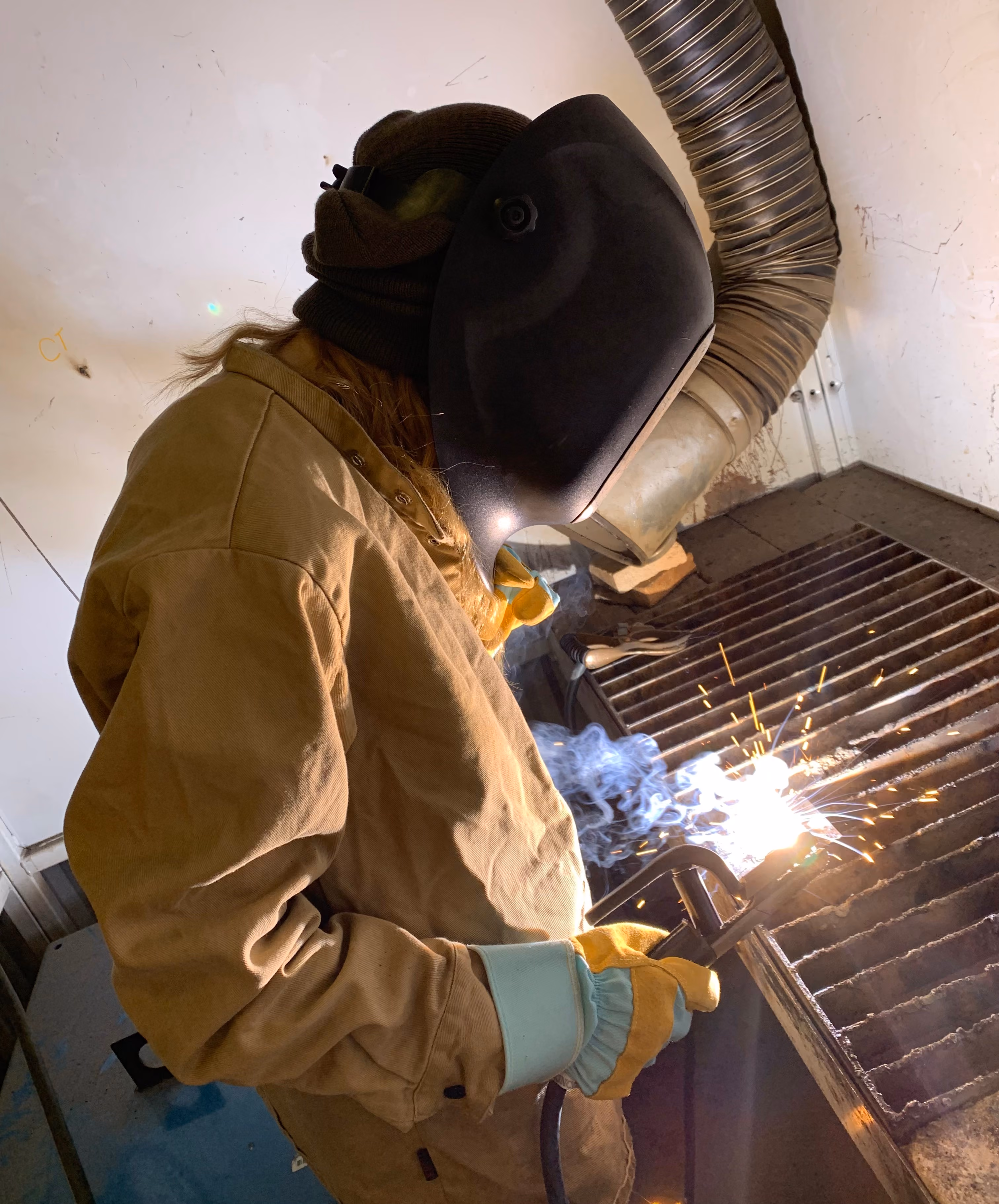 A student welding in the high school shop