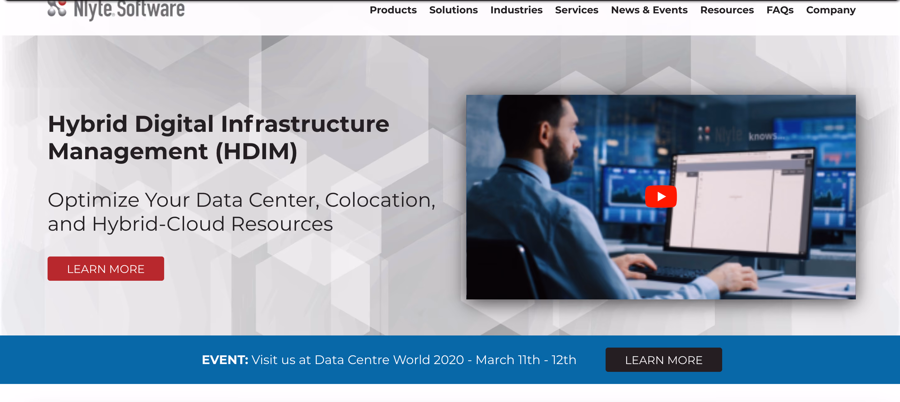 Man in office shirt working at multiple monitors showing data graphs and software interface with play button.