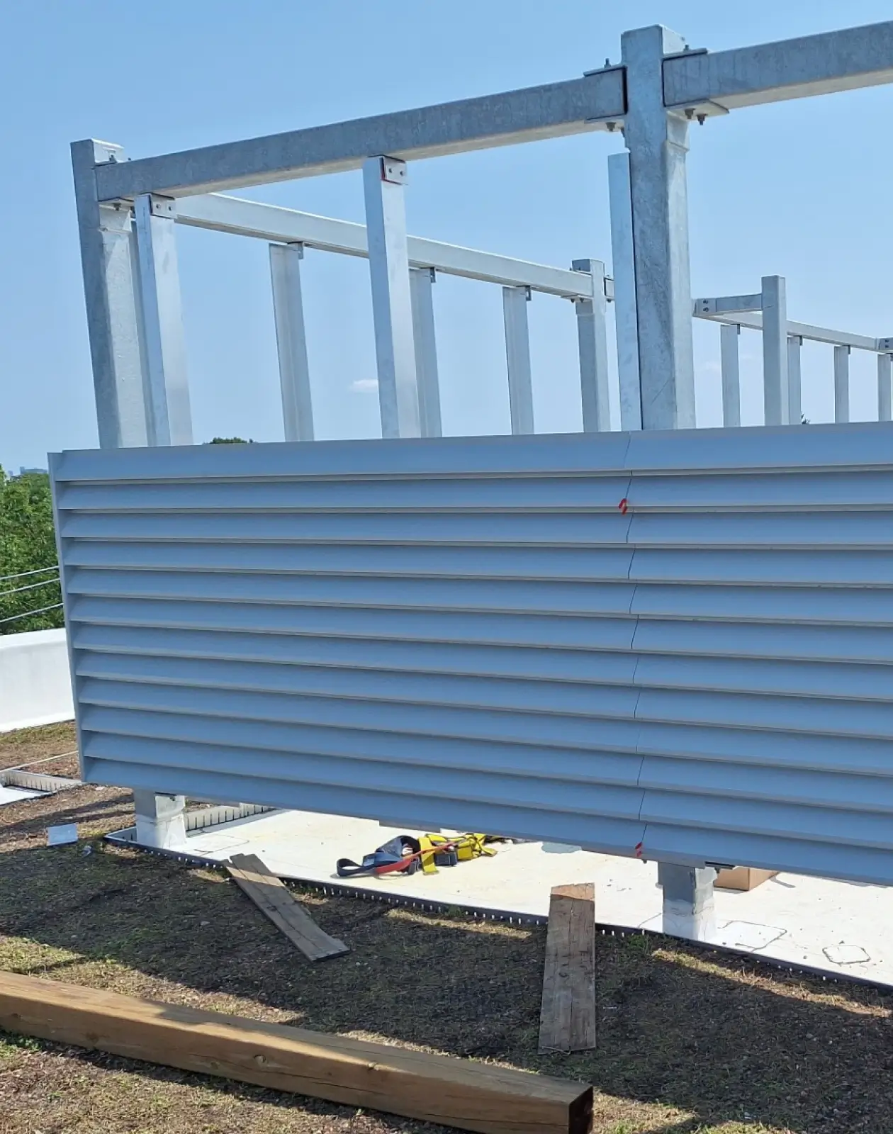 Architectural louvre screen system installed on a structural frame to provide screening, ventilation, and visual interest.
