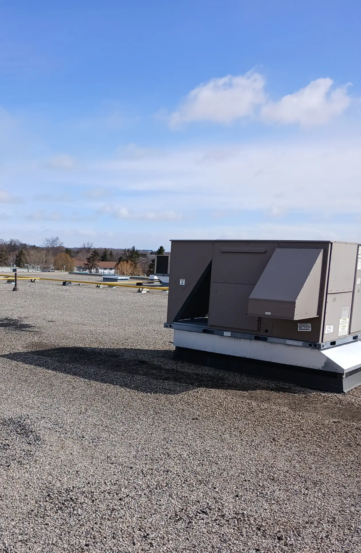 Built-up roofing (BUR) system installed on a low-slope commercial roof with gravel surfacing and rooftop mechanical equipment.