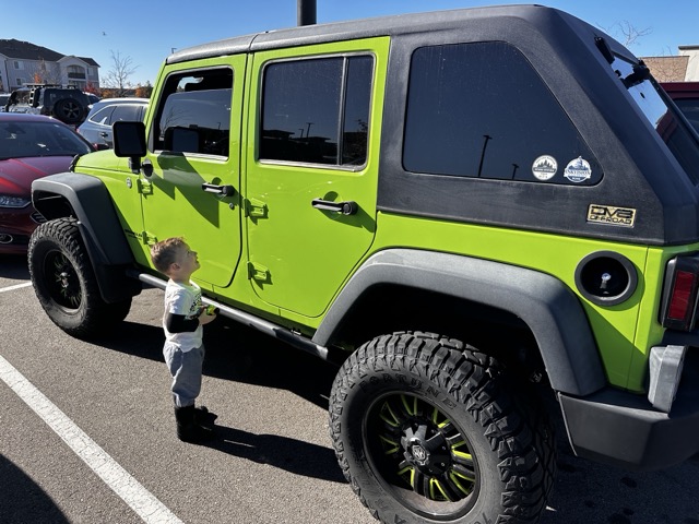 Grandson ducking a lime green Jeep