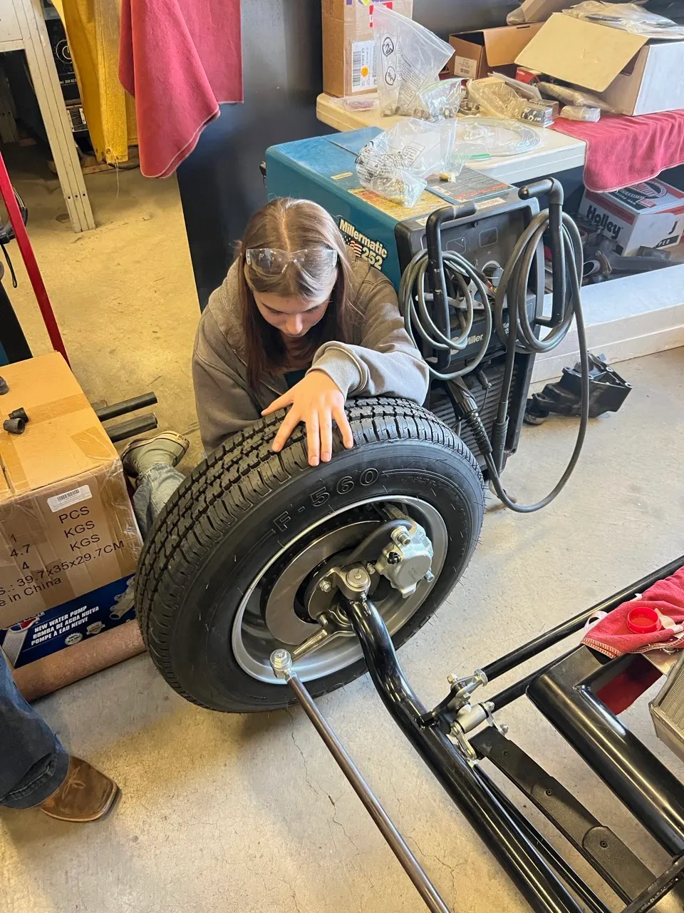 A student working on a wheel in the automotive shop