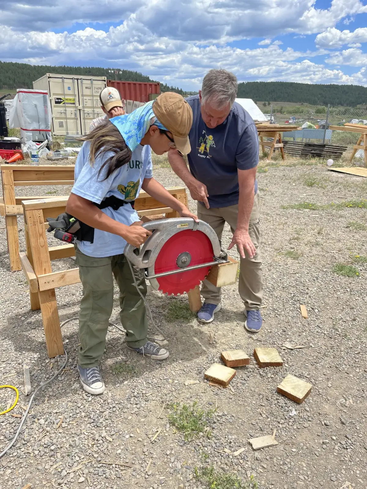 Boot camp students cutting lumber with a circular saw outdoors