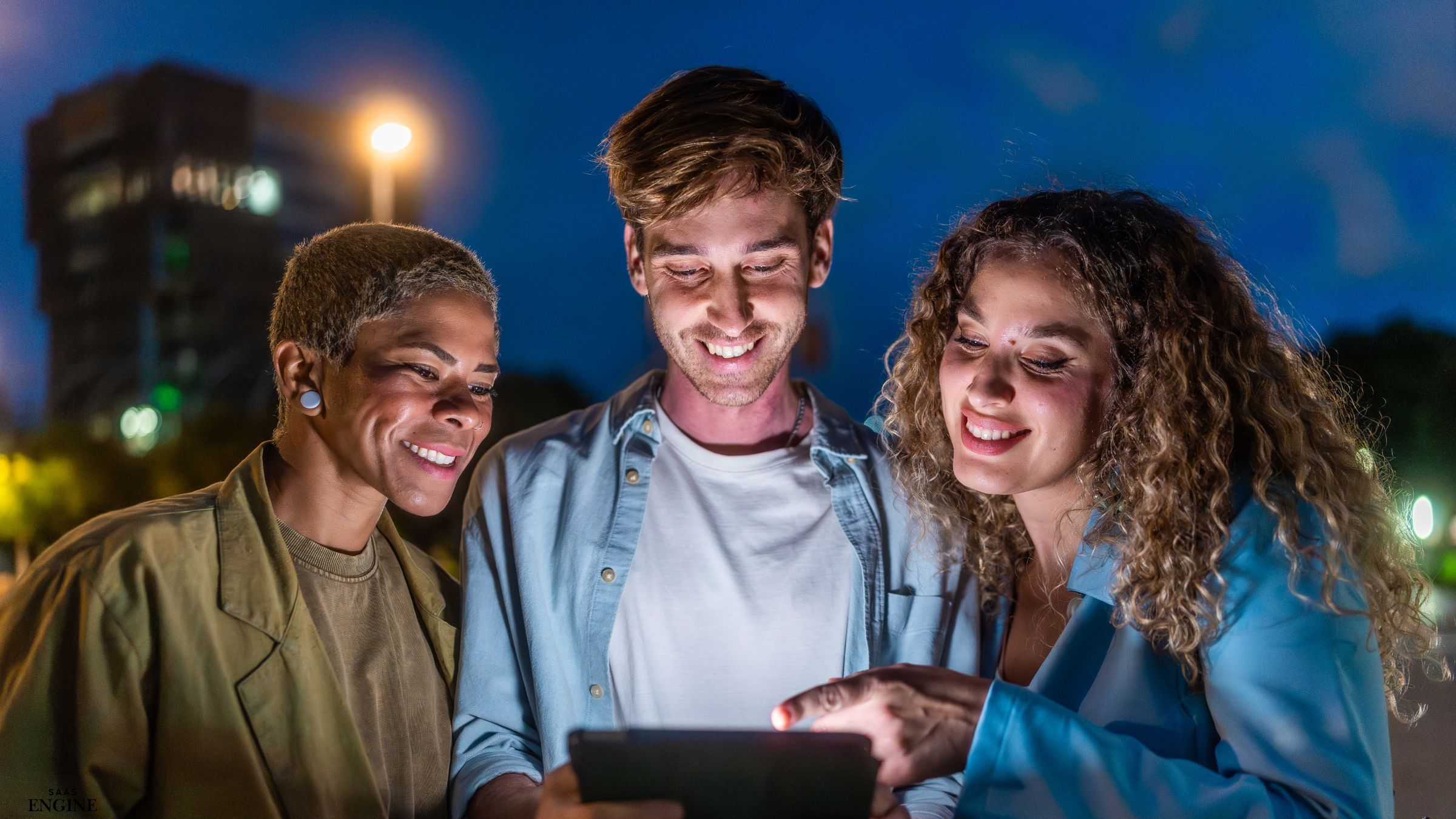 Three friends looking together at an iPad screen