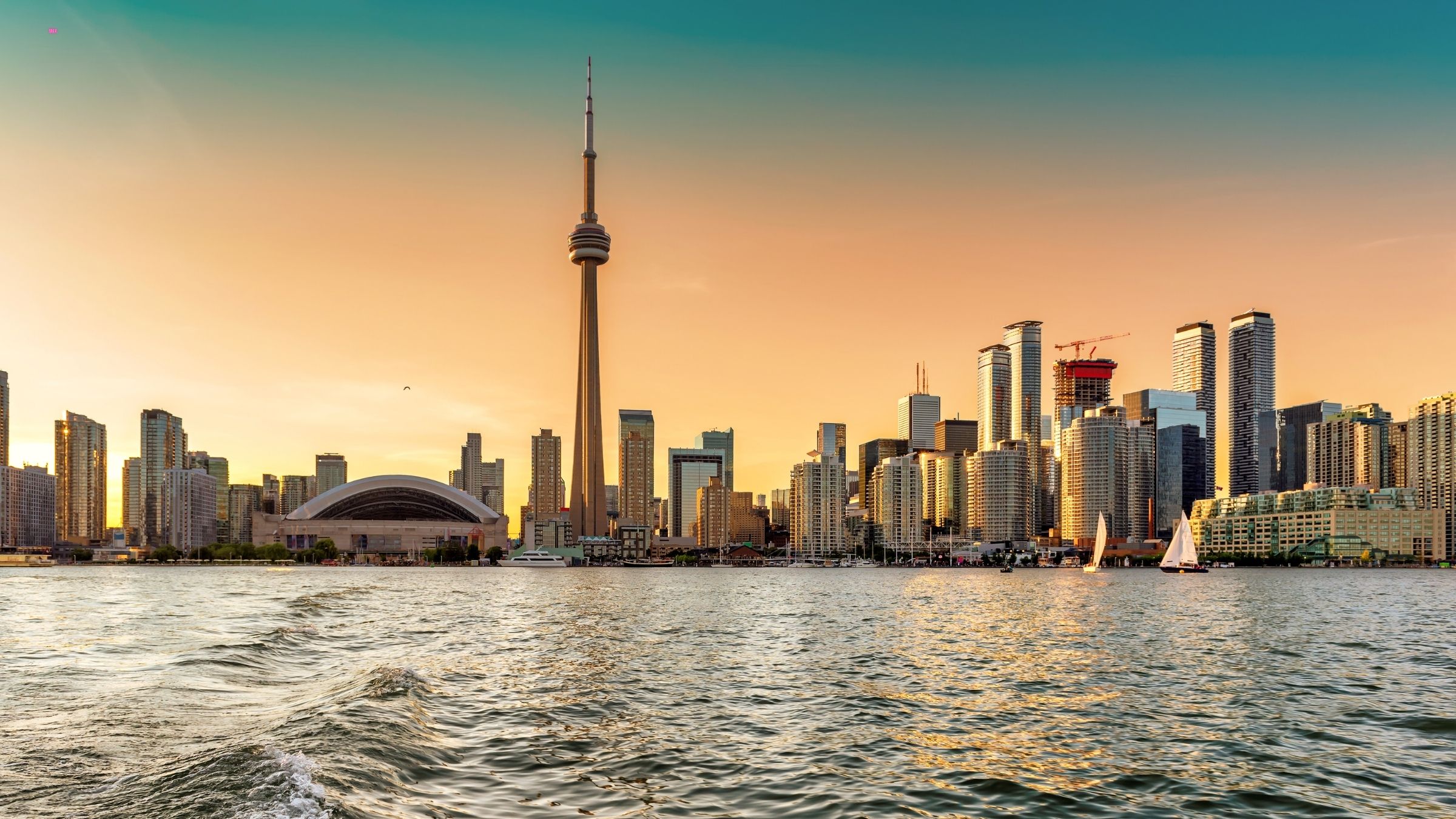 Clean view of the CN Tower from the lake alongside nearby buildings
