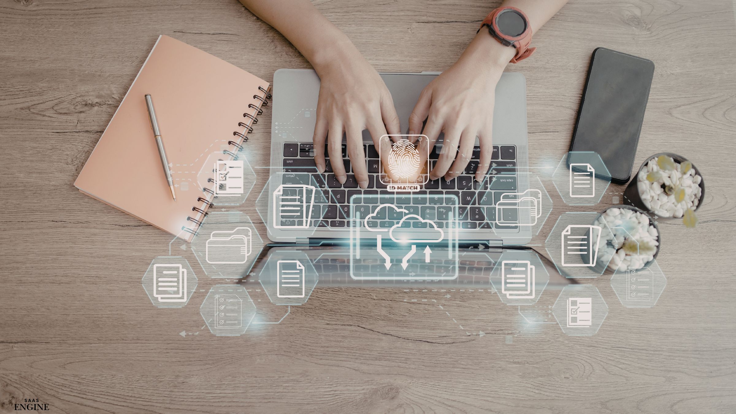 Hands typing on a laptop keyboard with IT icons overlaid, coffee cup and notebook nearby