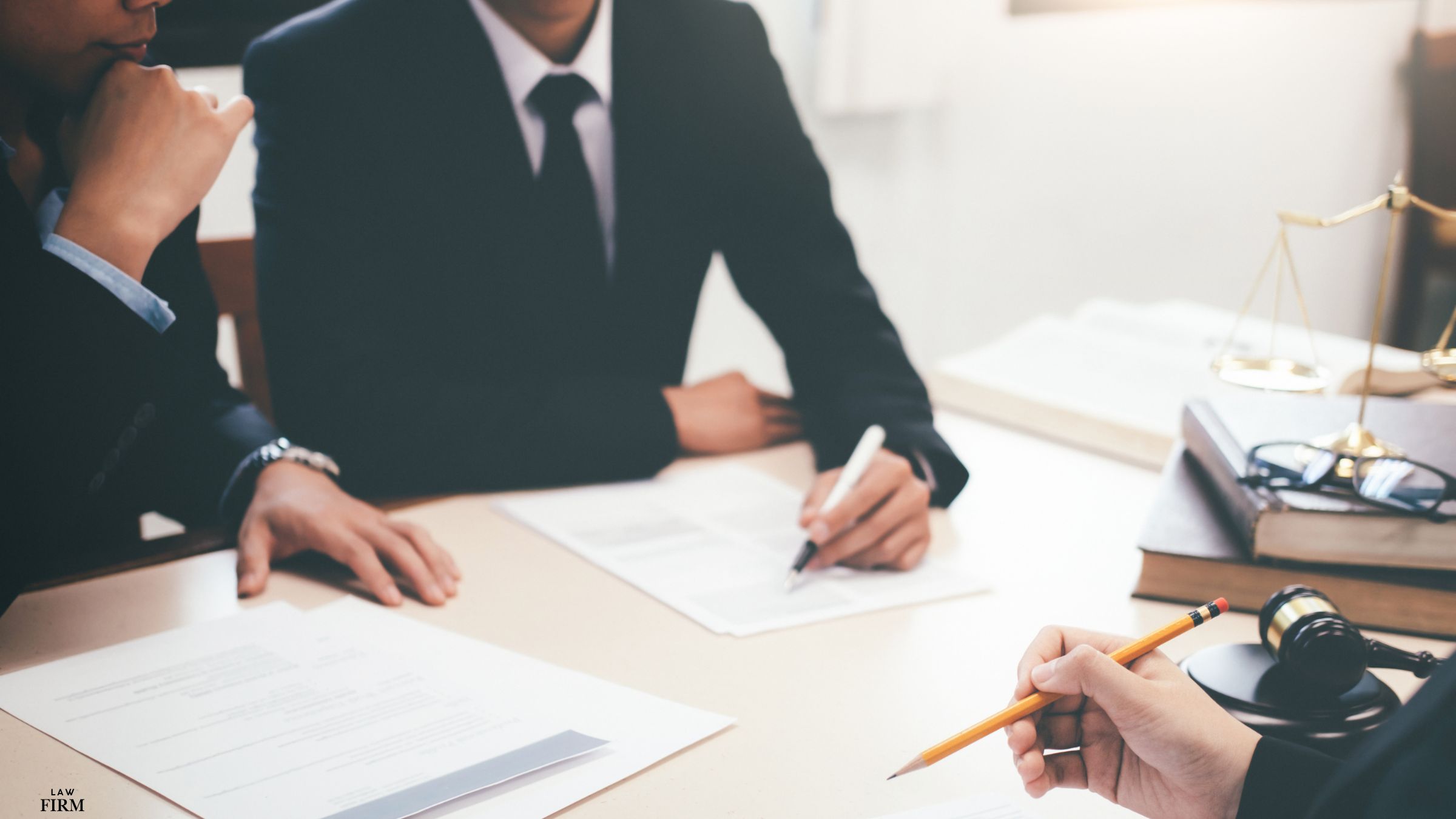 Team of legal professionals working together at a table with papers and pens