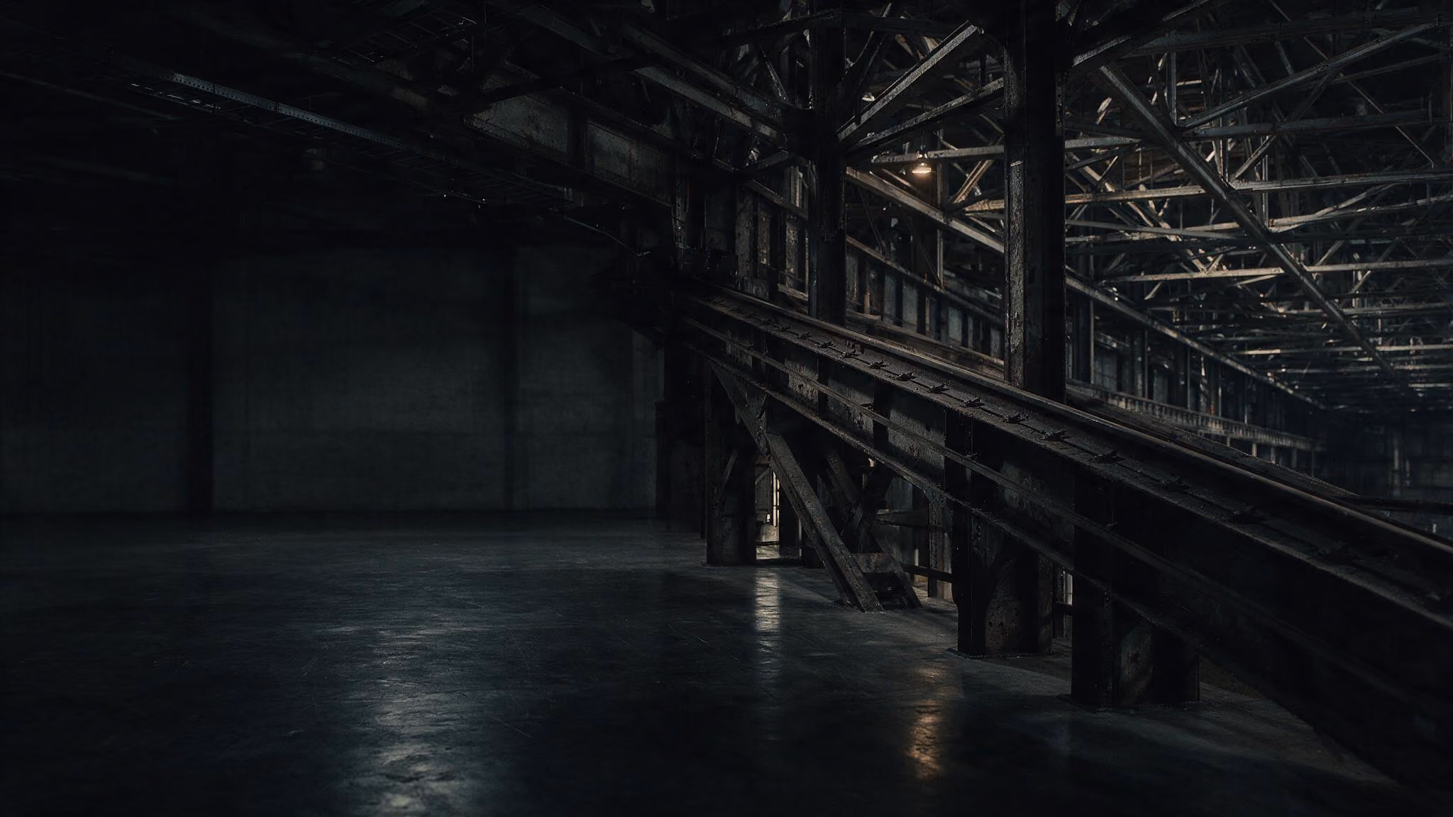Dark spacious industrial warehouse interior with metal beams and a reflective concrete floor.