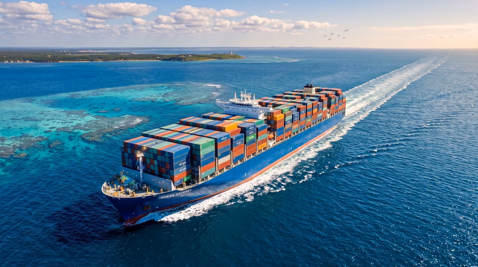 A large cargo ship loaded with colorful shipping containers sailing on clear blue ocean waters