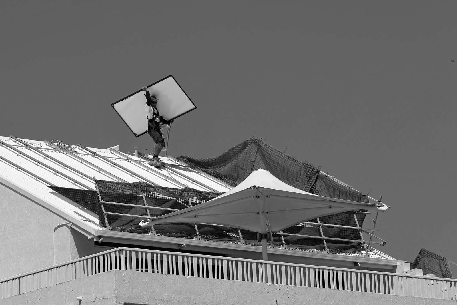 A tradie up on a roof, on the tools