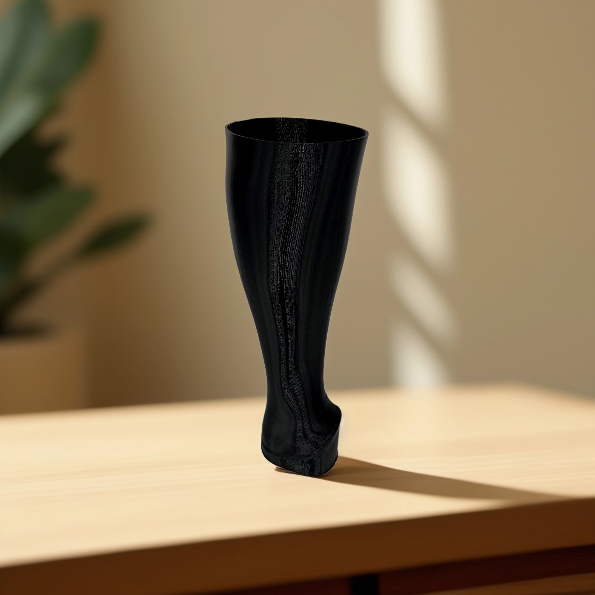 Black cosmetic tube standing upright on a wooden surface with natural light and shadows.