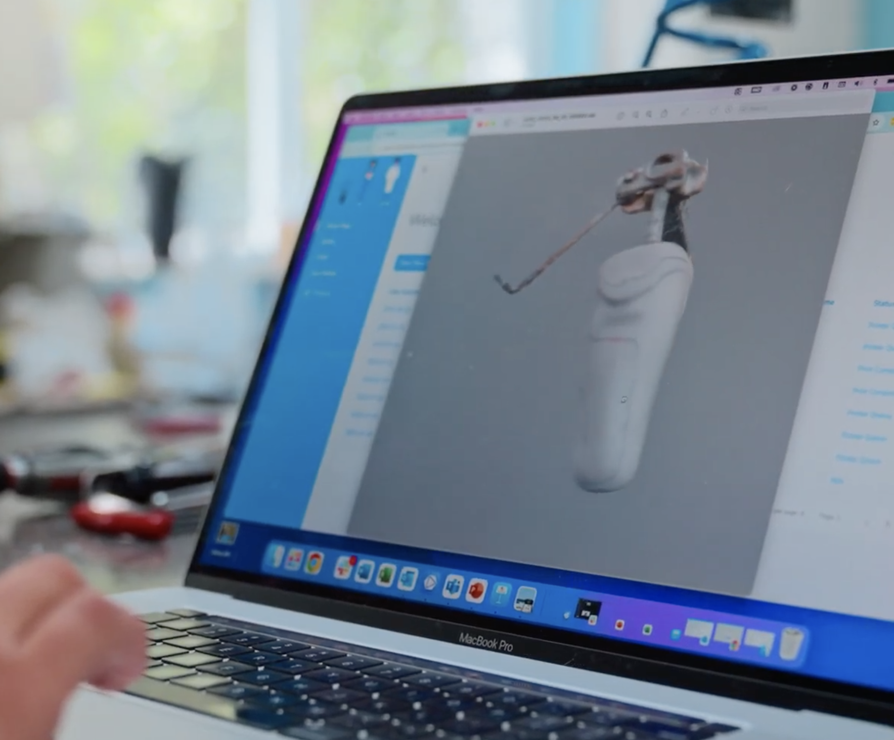 Close-up of a MacBook Pro screen showing a 3D model of a prosthetic limb being designed.