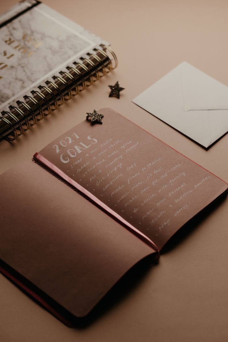 An open notebook with a handwritten goals list on a desk, ready for planning