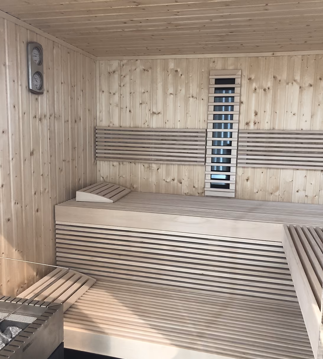 Kit-set sauna with slatted timber benches and infrared panel