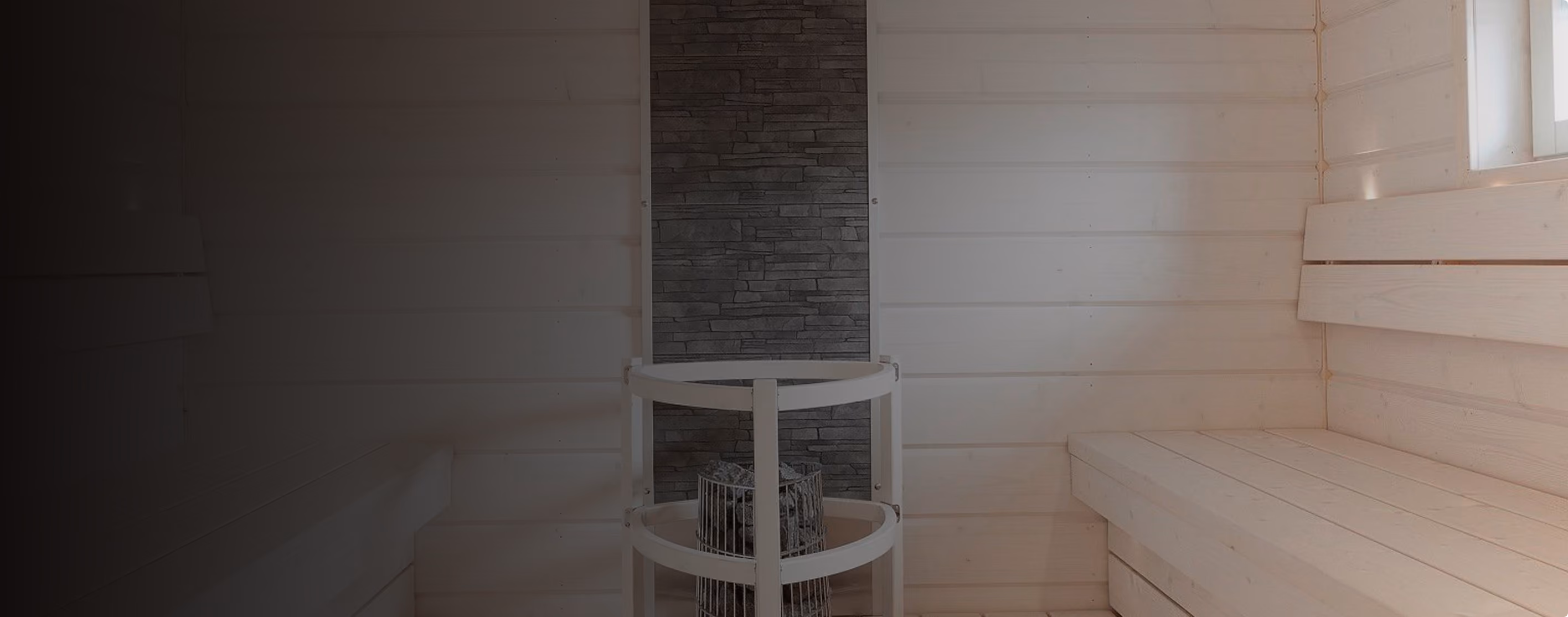 White timber sauna with a round sauna heater and stone feature wall