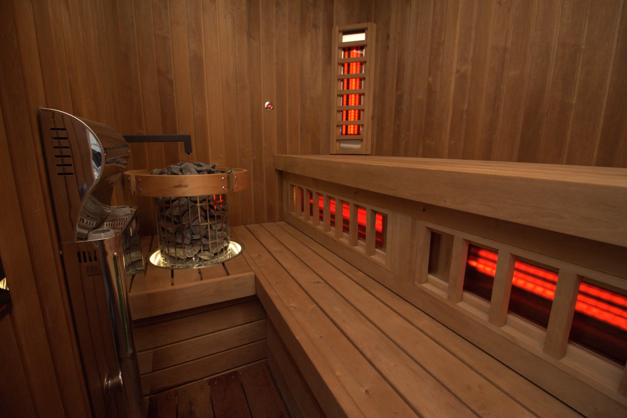 Hybrid sauna with infrared panels in the backrests and a traditional sauna heater