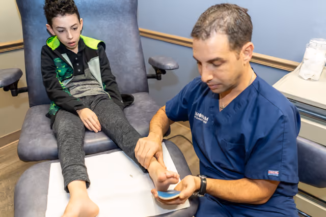 Child's feet being examined by a podiatrist at Timonium Foot and Ankle Center