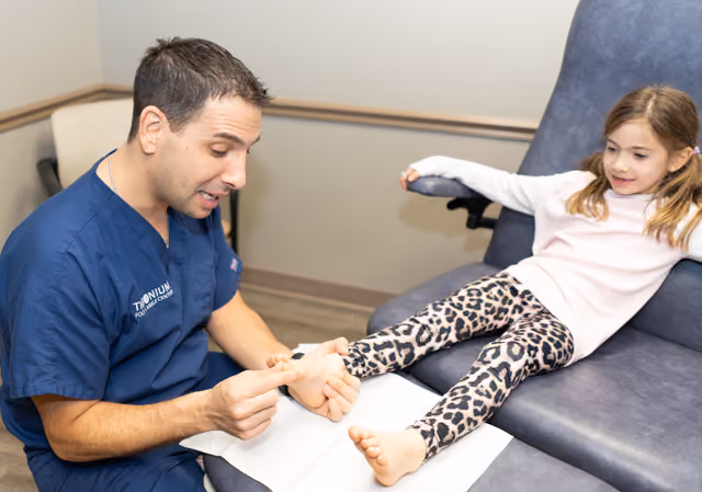 Dr. Stewart examining a young patient's foot at Timonium Foot and Ankle Center
