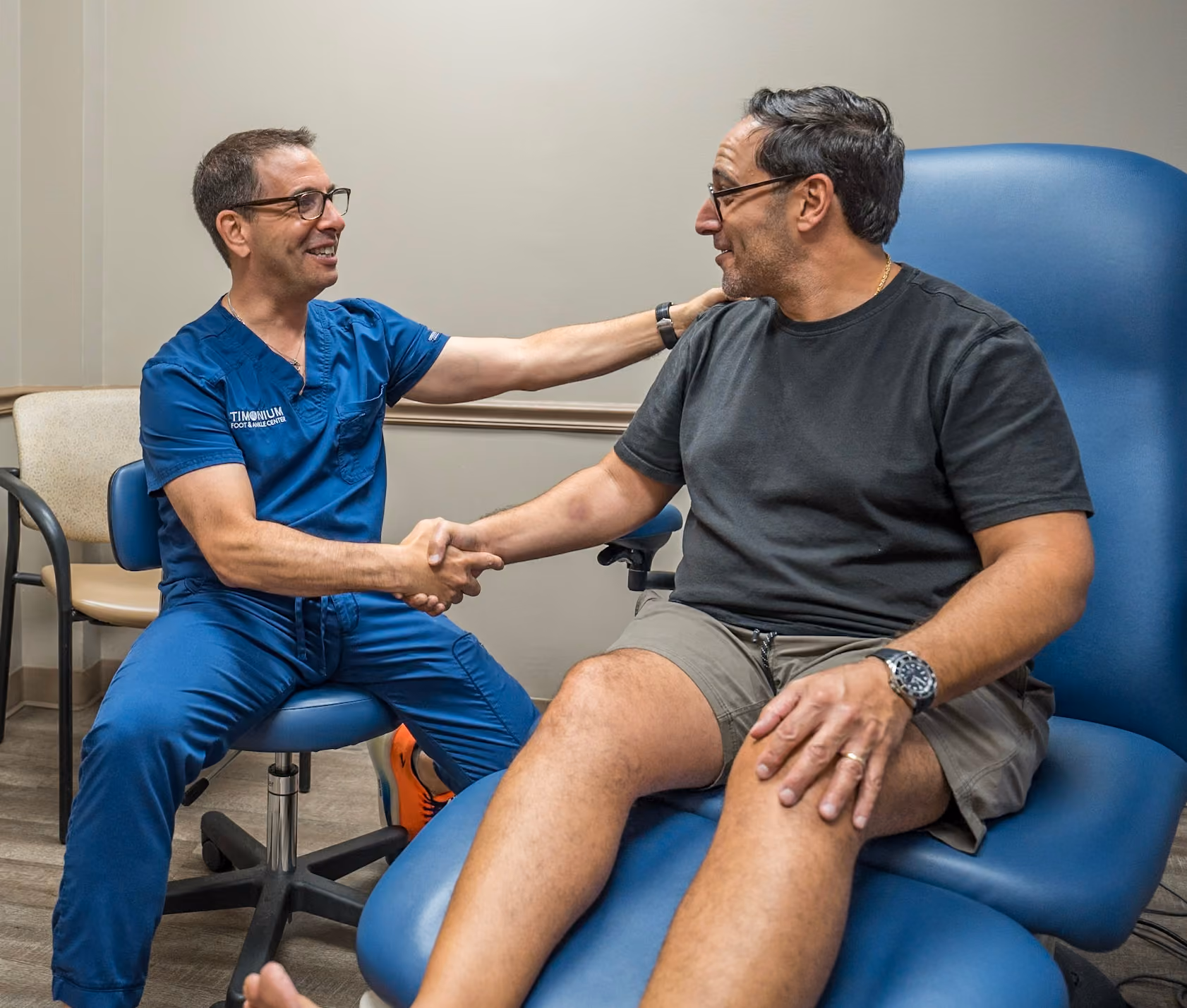 Dr. Jordan Stewart shaking hands with a patient after a conservative foot care visit in Timonium, MD