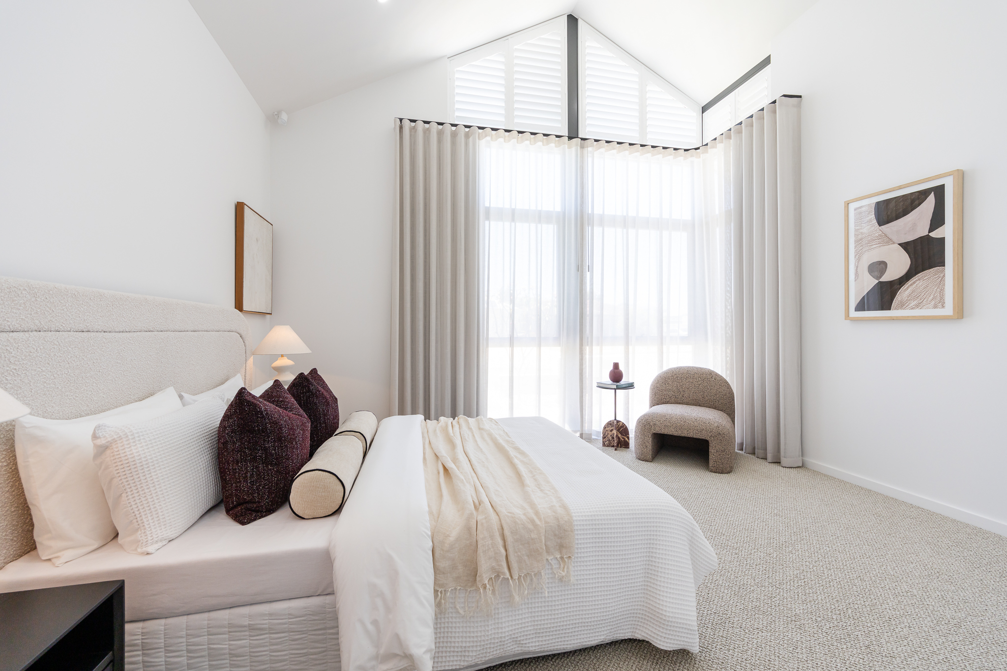 Styled bedroom with vaulted ceiling and sheer drapery